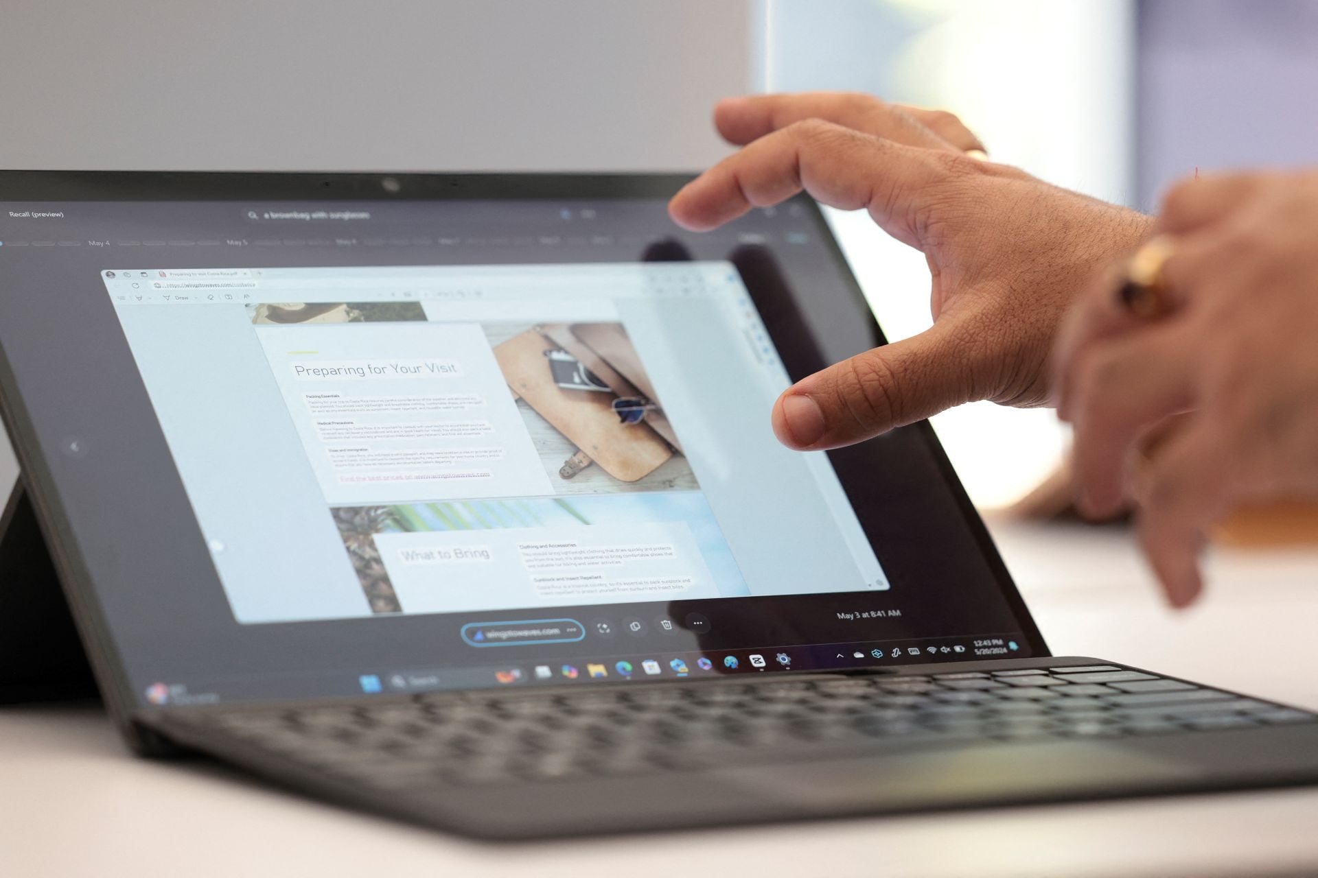 Windows 11 Recall shown on a screen with somebody scrolling the touchscreen.