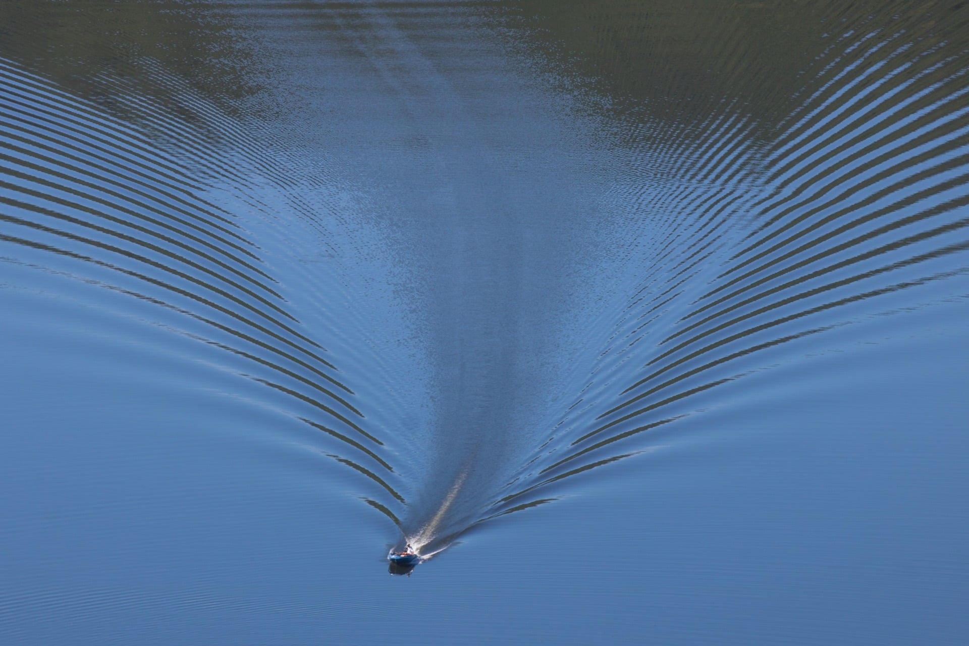 V-shaped wakes trail behind boats or waterfowl gliding in water. Research suggests some solids can support similar phenomena.