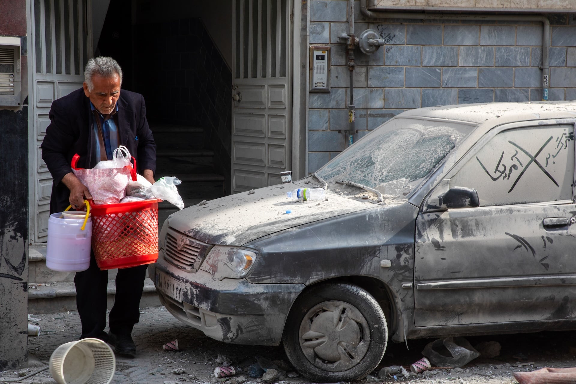 A man carries belongings in the aftermath of a US-Israeli strike on a residential building that also destroyed the adjacent Rafi-Nia Synagogue on April 7, 2026, in Tehran, Iran. 