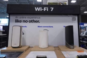 A Netgear router and two others on a shelf in a store
