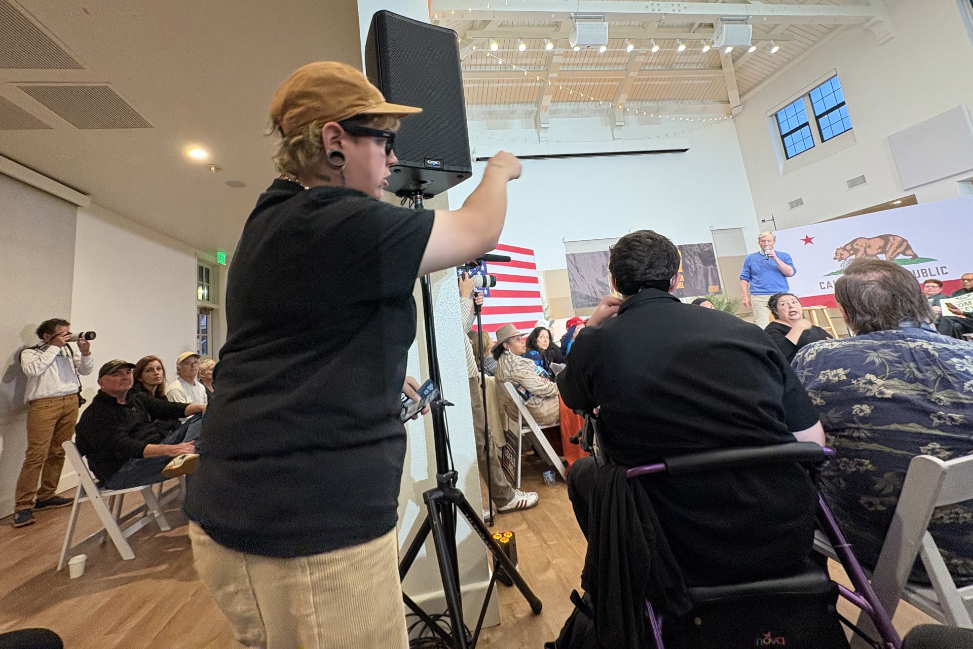 Um dos três manifestantes do Coletivo de Detenção anti-ICE Otay Mesa que se levantou durante a prefeitura de Tom Steyer e expressou oposição ao dinheiro que ganhou investindo na empresa prisional privada CoreCivic.