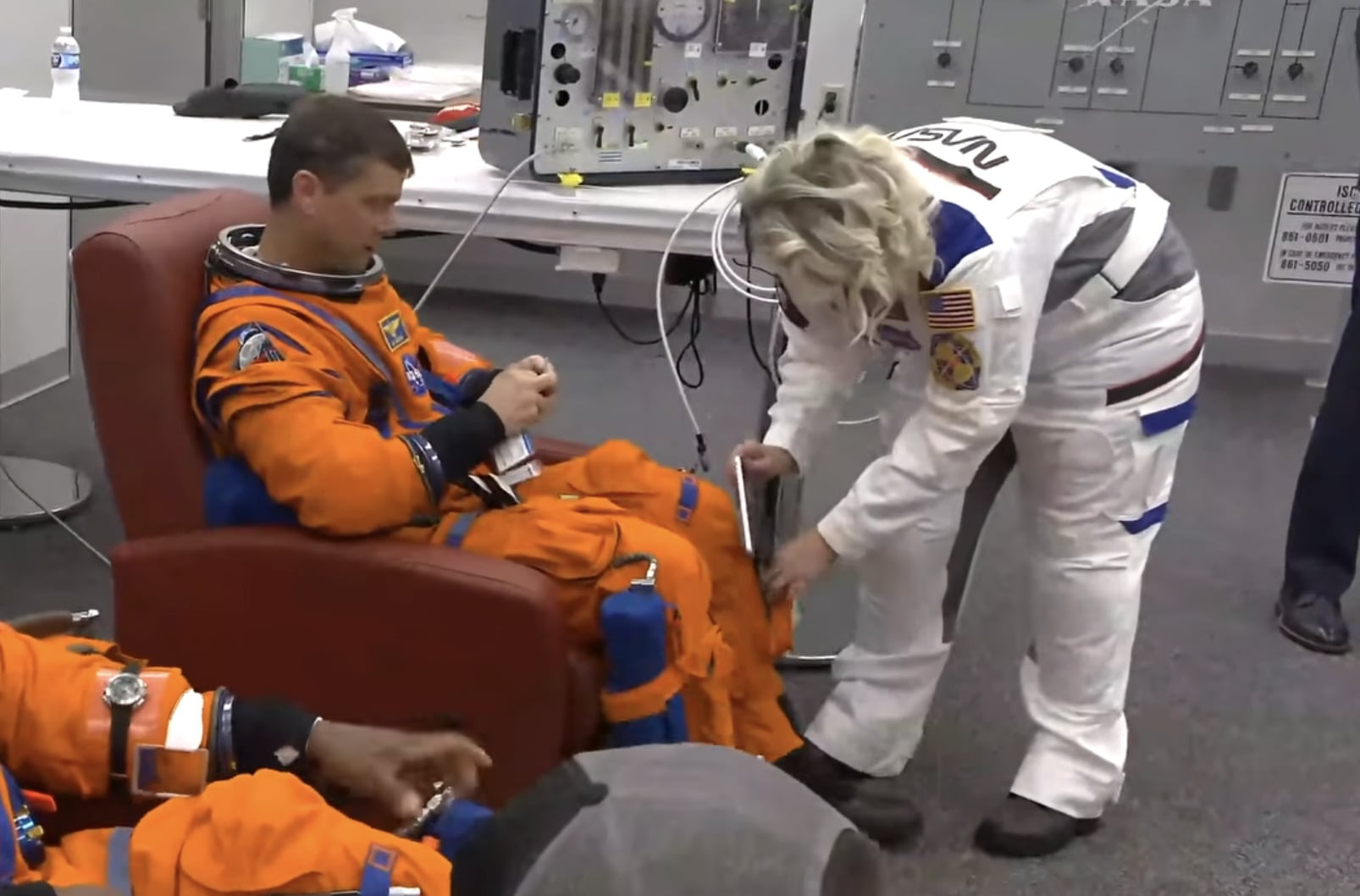 Astronaut Reid Weisman having an iPhone placed in his pocket by a NASA employee