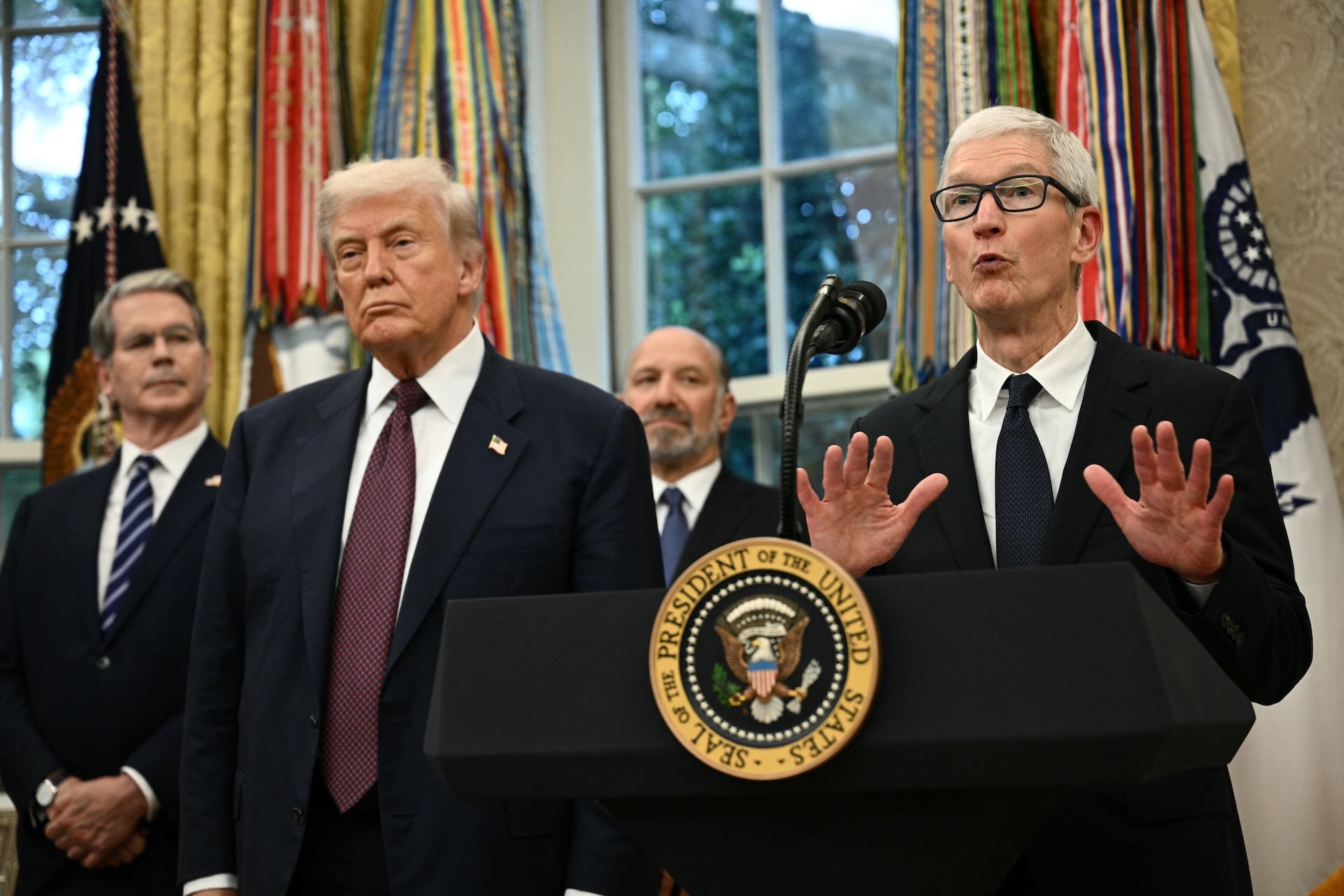 Apple CEO Tim Cook speaks as US President Donald Trump, (2nd L), Commerce Secretary Howard Lutnick (2nd R) and Treasury Secretary Scott Bessent (L) look on in the Oval Office of the White House in Washington, DC. 