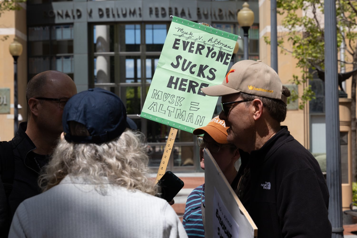 Demonstrators outside of the courthouse where the lawsuit between Elon Musk and OpenAI is taking place