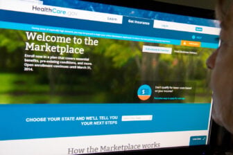 A woman reading the HealthCare.gov insurance marketplace on a laptop