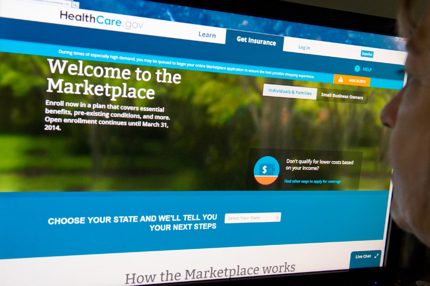 A woman reading the HealthCare.gov insurance marketplace on a laptop