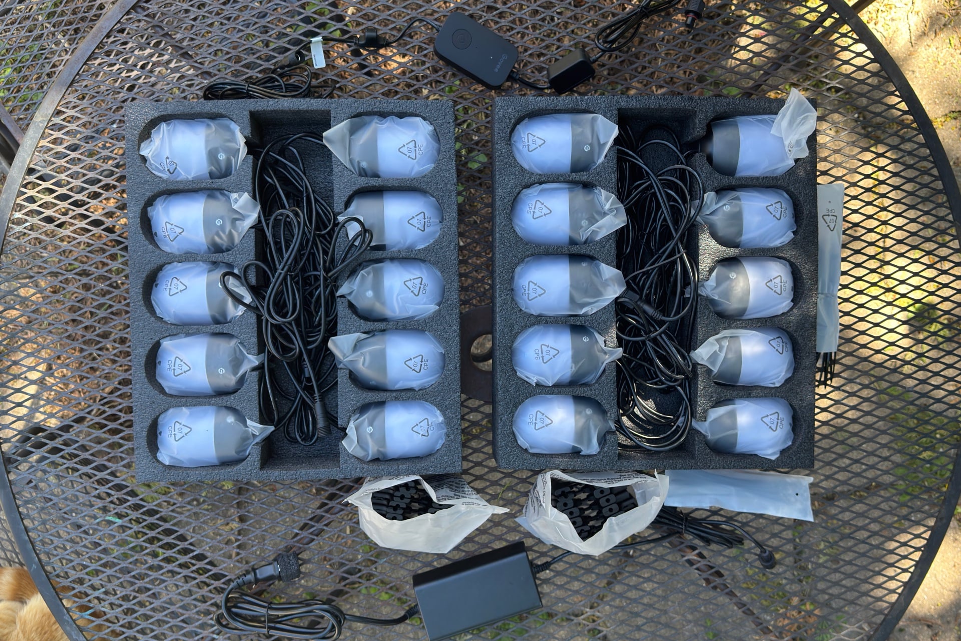 Govee Outdoor Chromatic String Lights in their packaging, with various pieces laid around them.