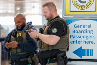 ICE agents seen at an airport using their phones.
