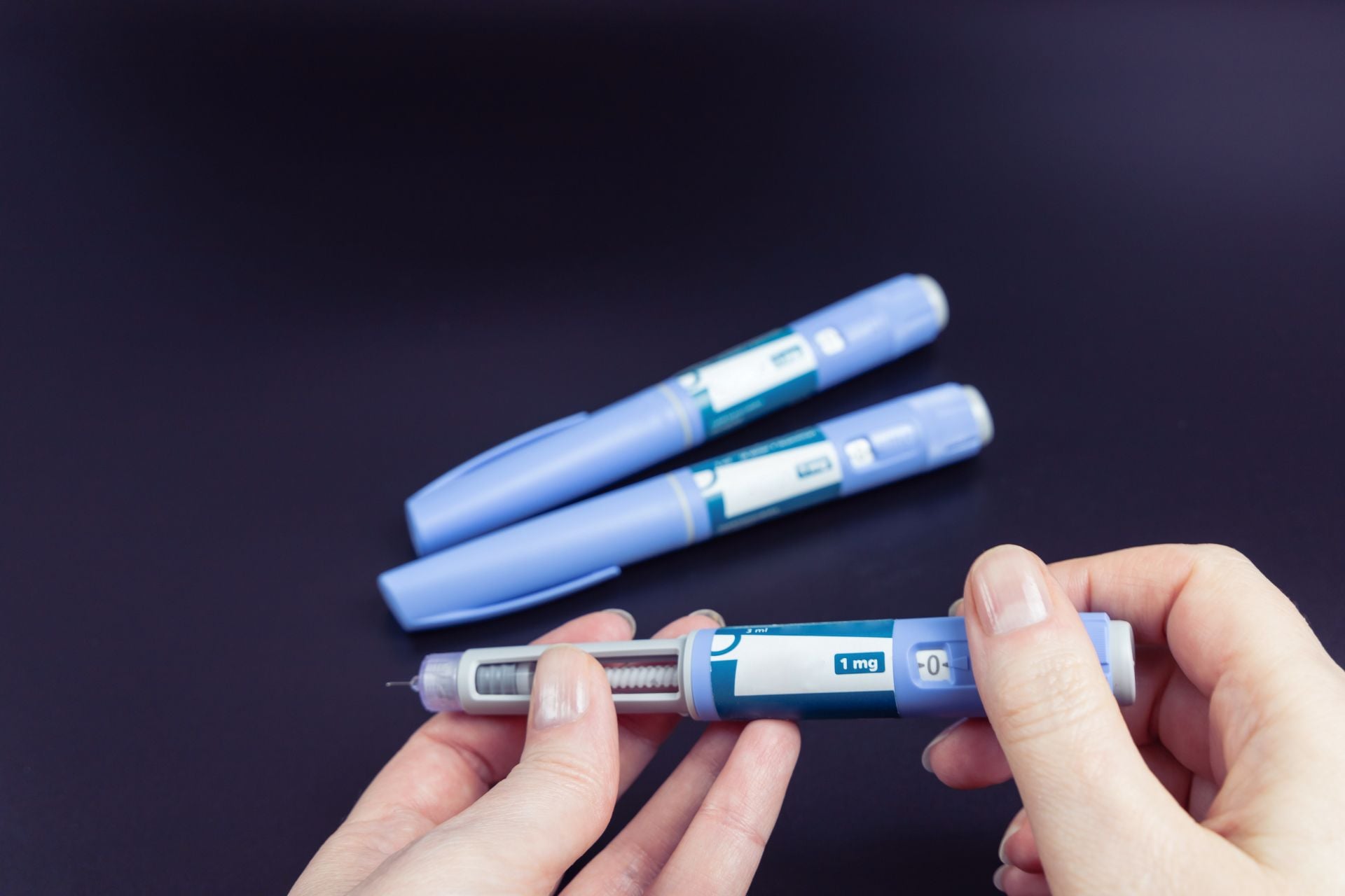 A person holding an Ozempic injection pen.