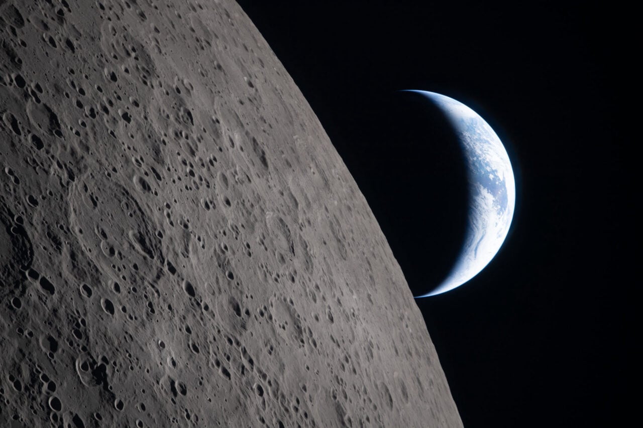 A view of the Moon with Earth setting in the background.