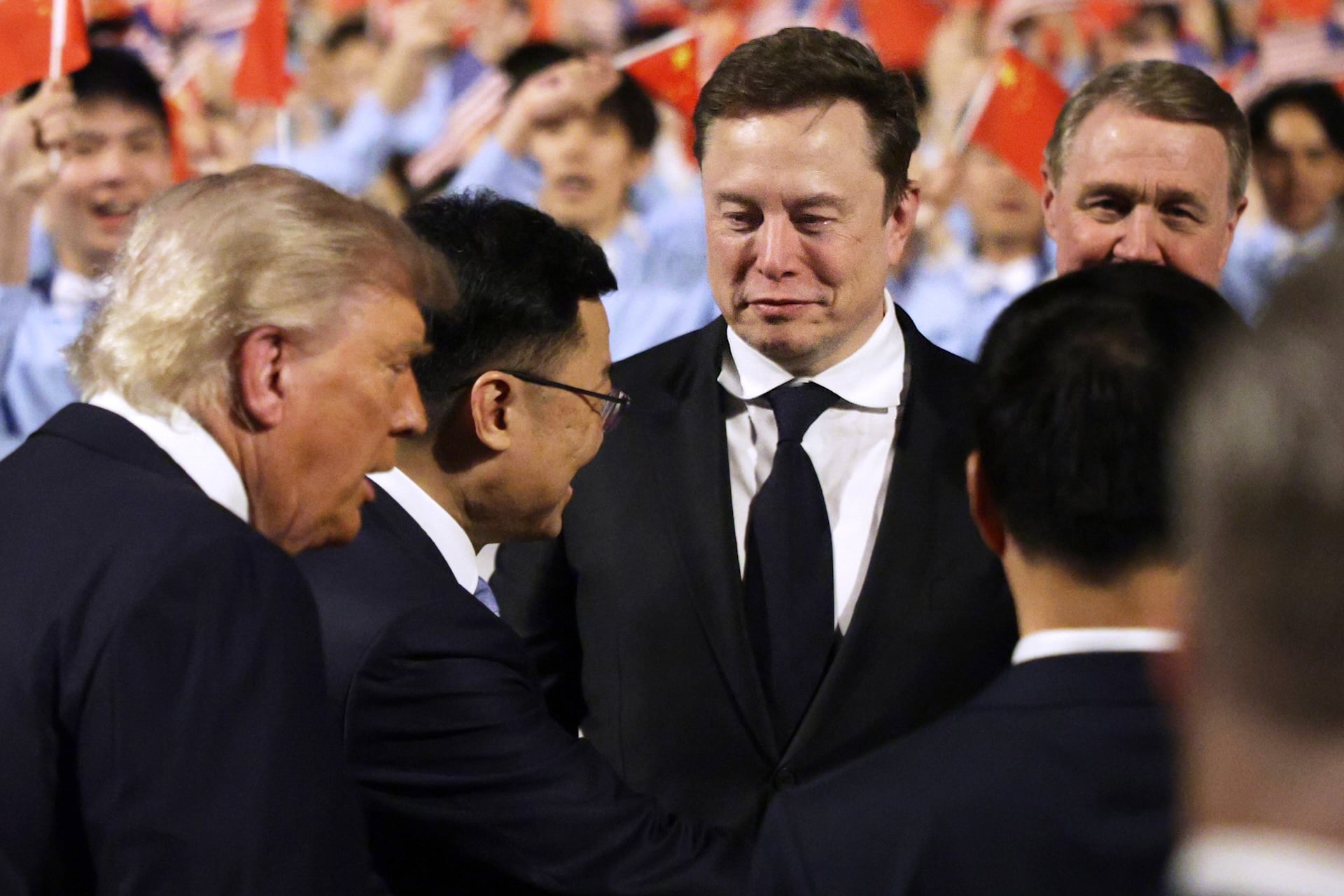 Elon Musk follows U.S. President Donald Trump on the red carpet upon arrival at Beijing Capital International Airport on May 13, 2026 in Beijing, China.  