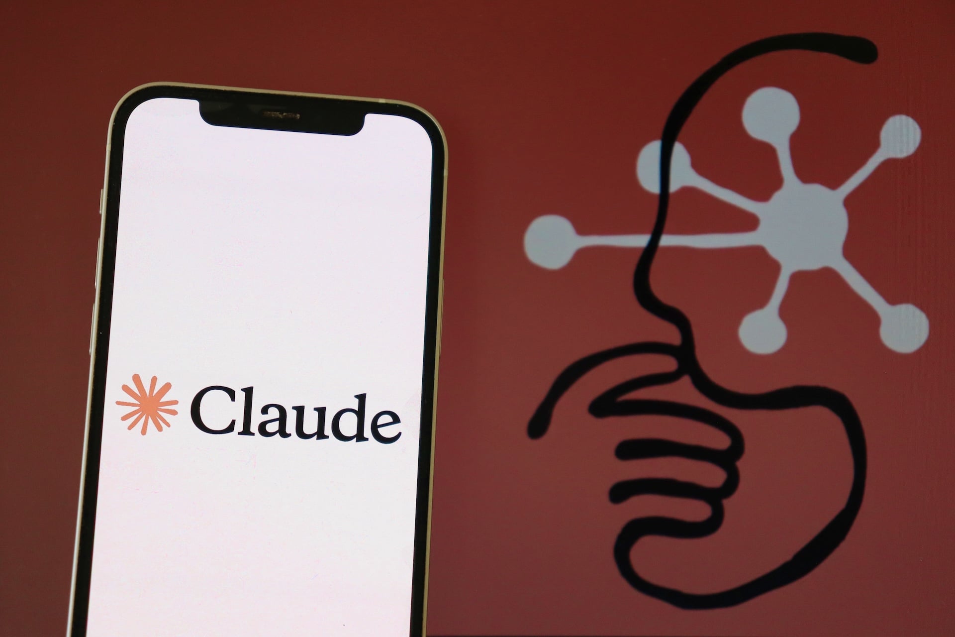 The Claude logo is displayed on a smartphone screen.