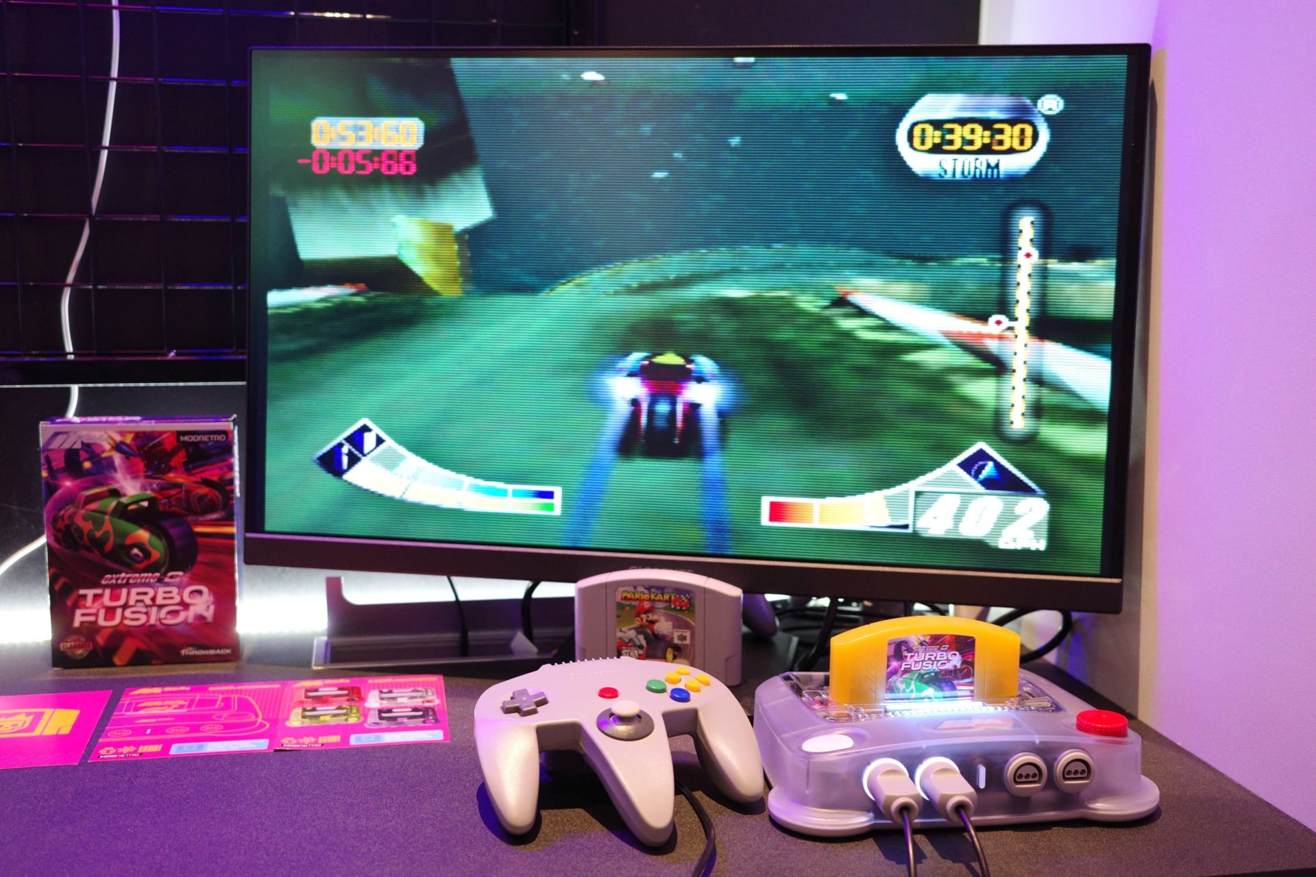 ModRetro M64 playing with controllers in front and a game running on a screen.