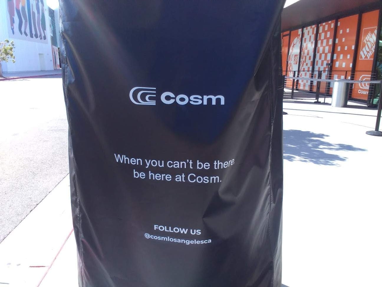 A sign outside Cosm, saying "When you can't be there, be here at Cosm."