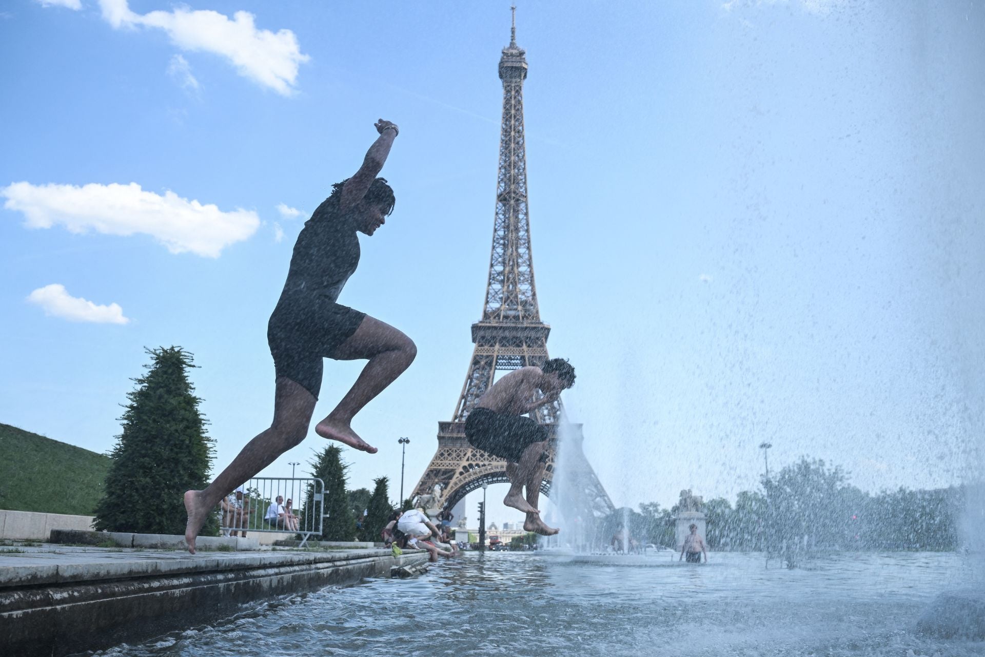 People jump in the Trocadero Fountain near the Eiffel Tower during a heatwave in Paris on June 22, 2026.
