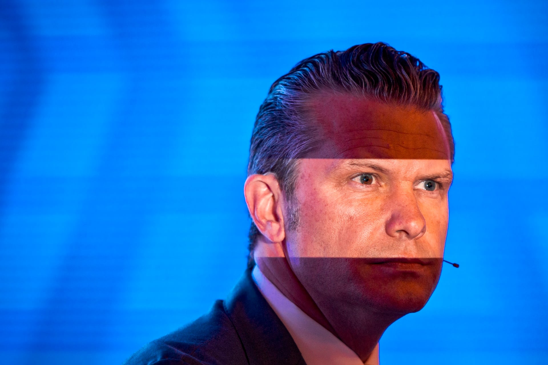 A photographer's flash partly illuminates U.S. Secretary of War Pete Hegseth's face during the 23rd IISS Shangri-La Dialogue at the Shangri-La Hotel on May 30, 2026 in Singapore. 