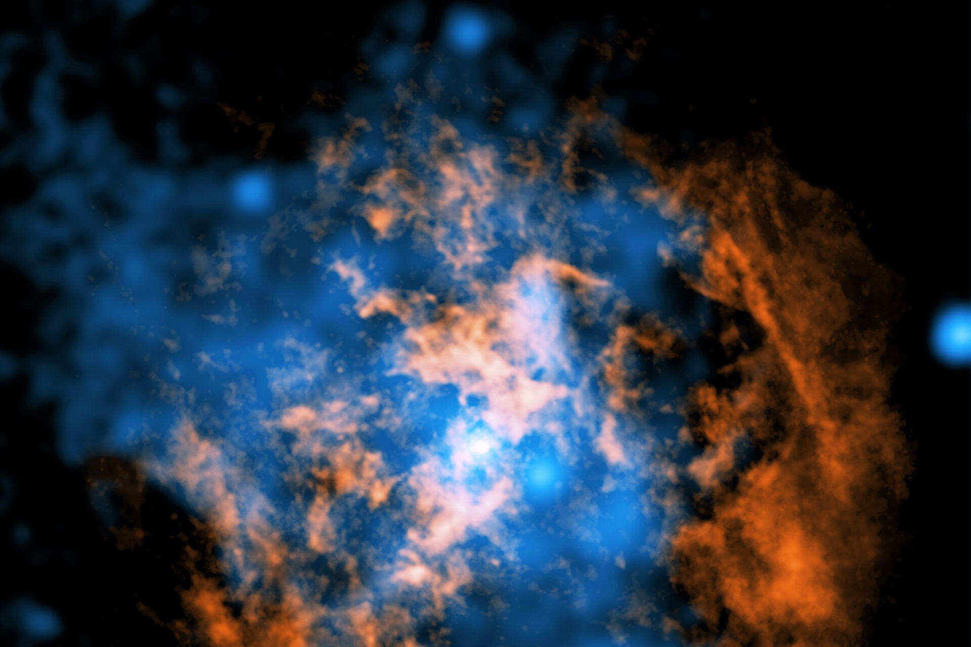 A composite image shows evidence for a wind blowing away from Sagittarius A*. In orange is ALMA data mapping the location of cold gas composed of carbon monoxide, whereas the blue represents Chandra X-ray data.