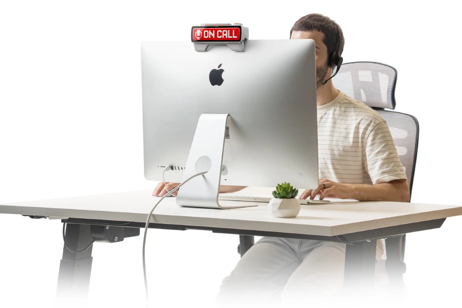 Busy device on an iMac while a person works behind a desk