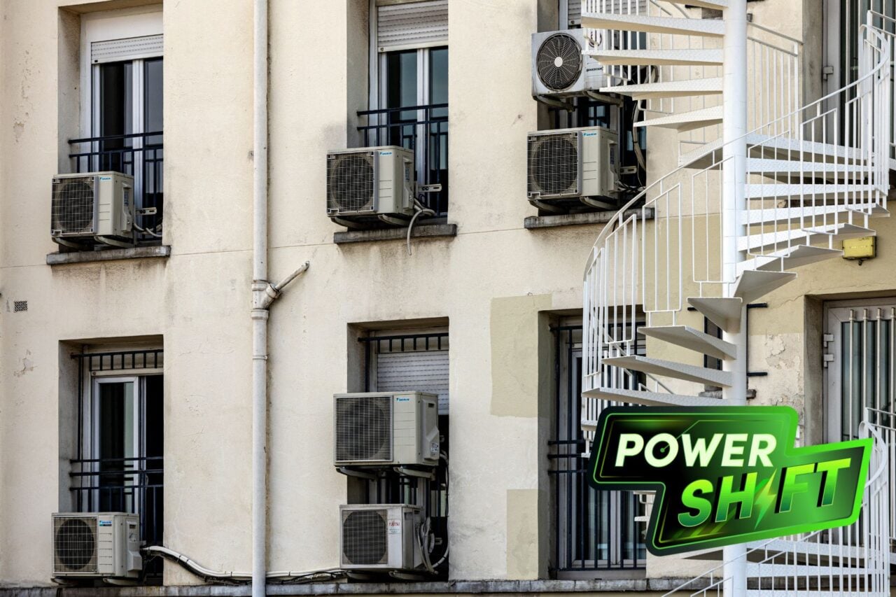 The facade of an apartment building with condensers of air conditioning units in the windows