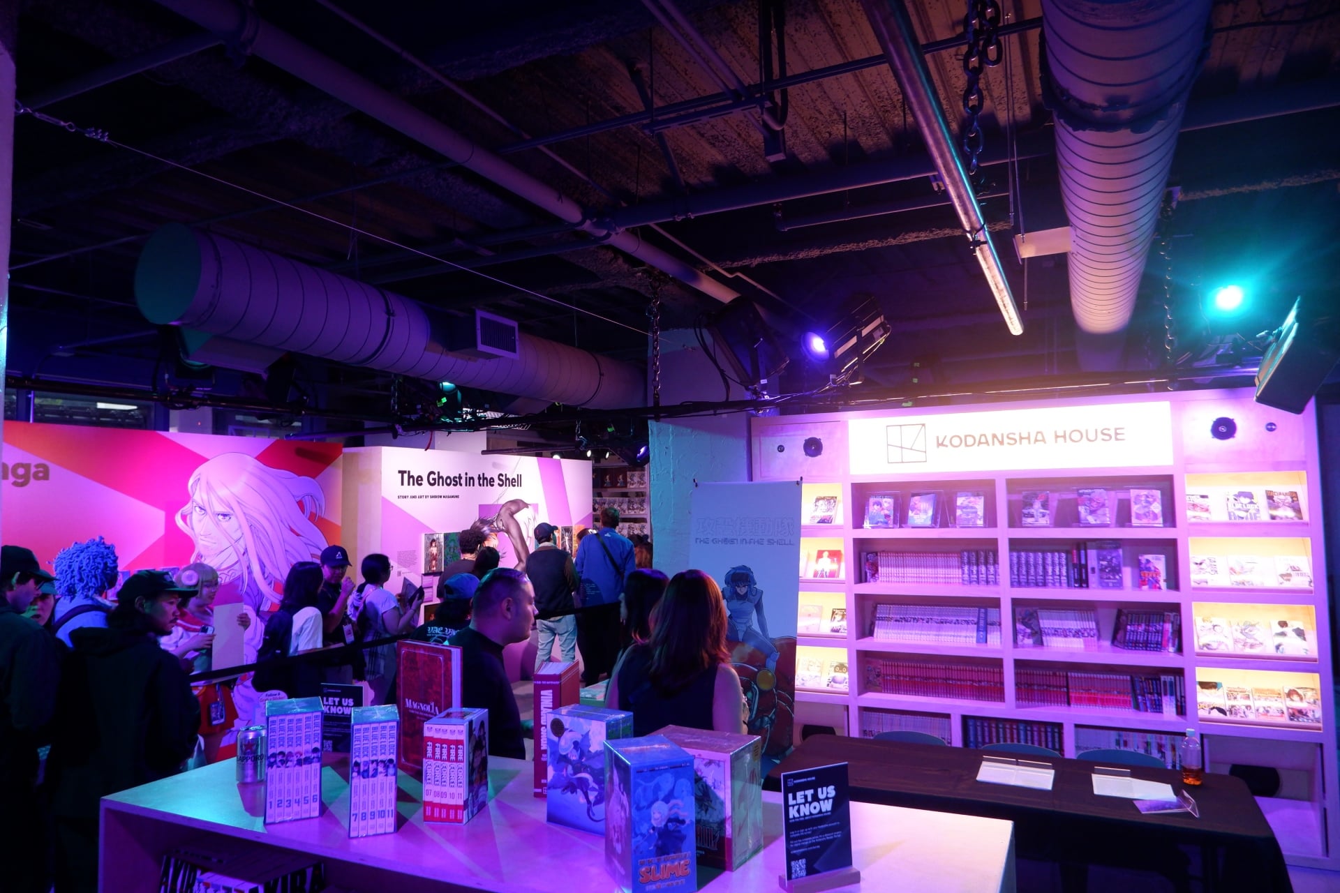Kodansha House photo of fans lined up to get autographs between shelves of manga.