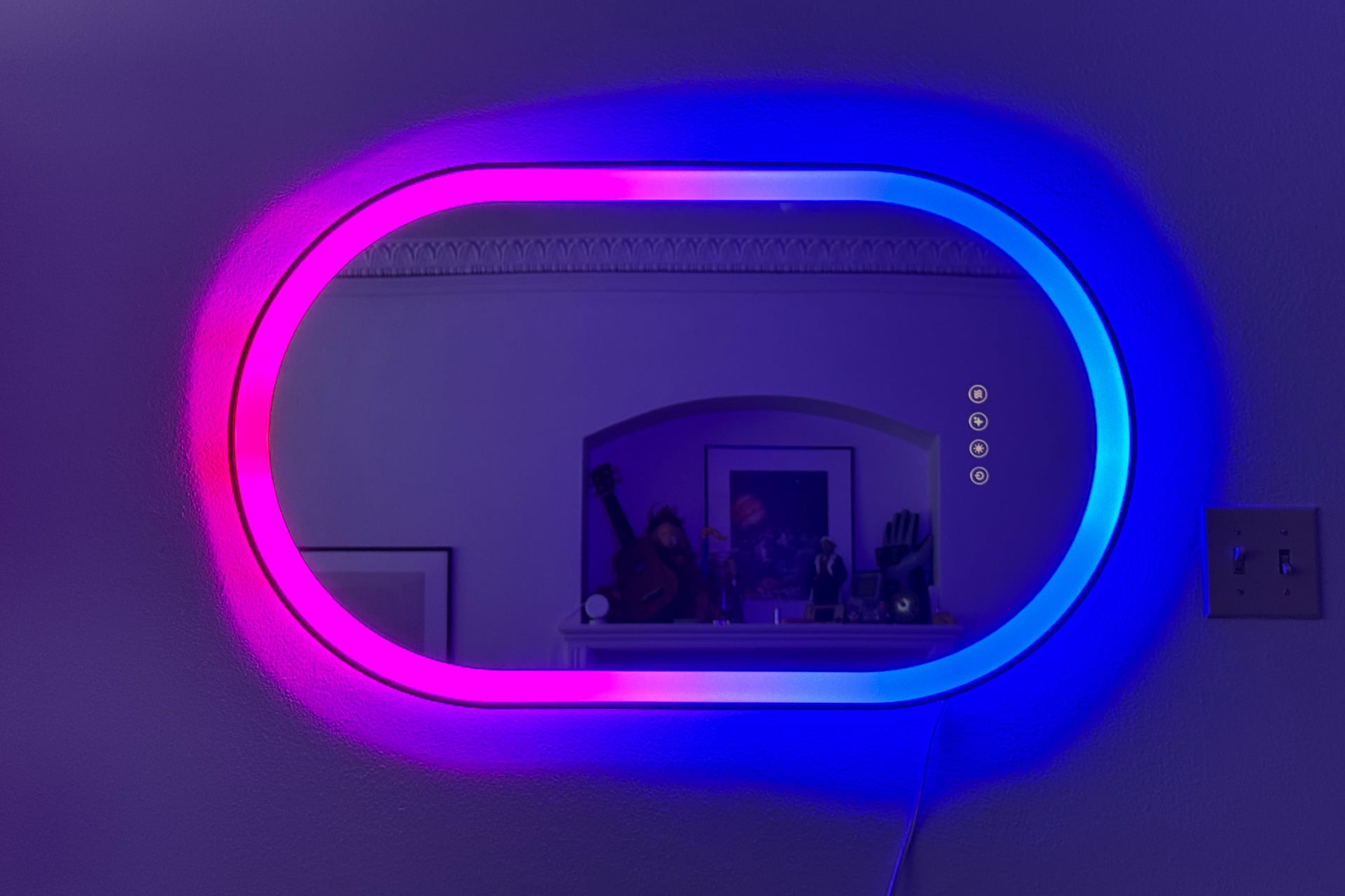 The lifx smart mirror with half of its LED ring in blue, half in pink, with a gradient where they meet in the middle at the top and bottom of the ring.