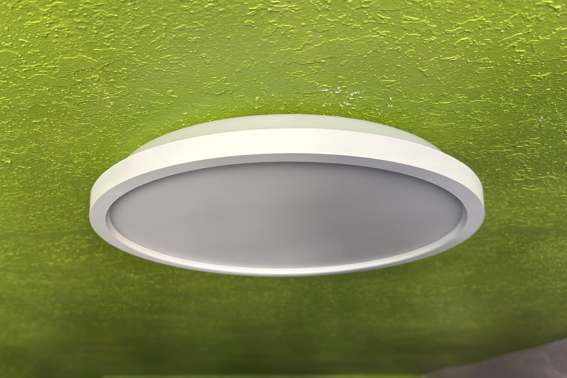 Nanoleaf Smart Multicolor turned off, pictured from a side angle to show how closely its body rests against the ceiling after install.