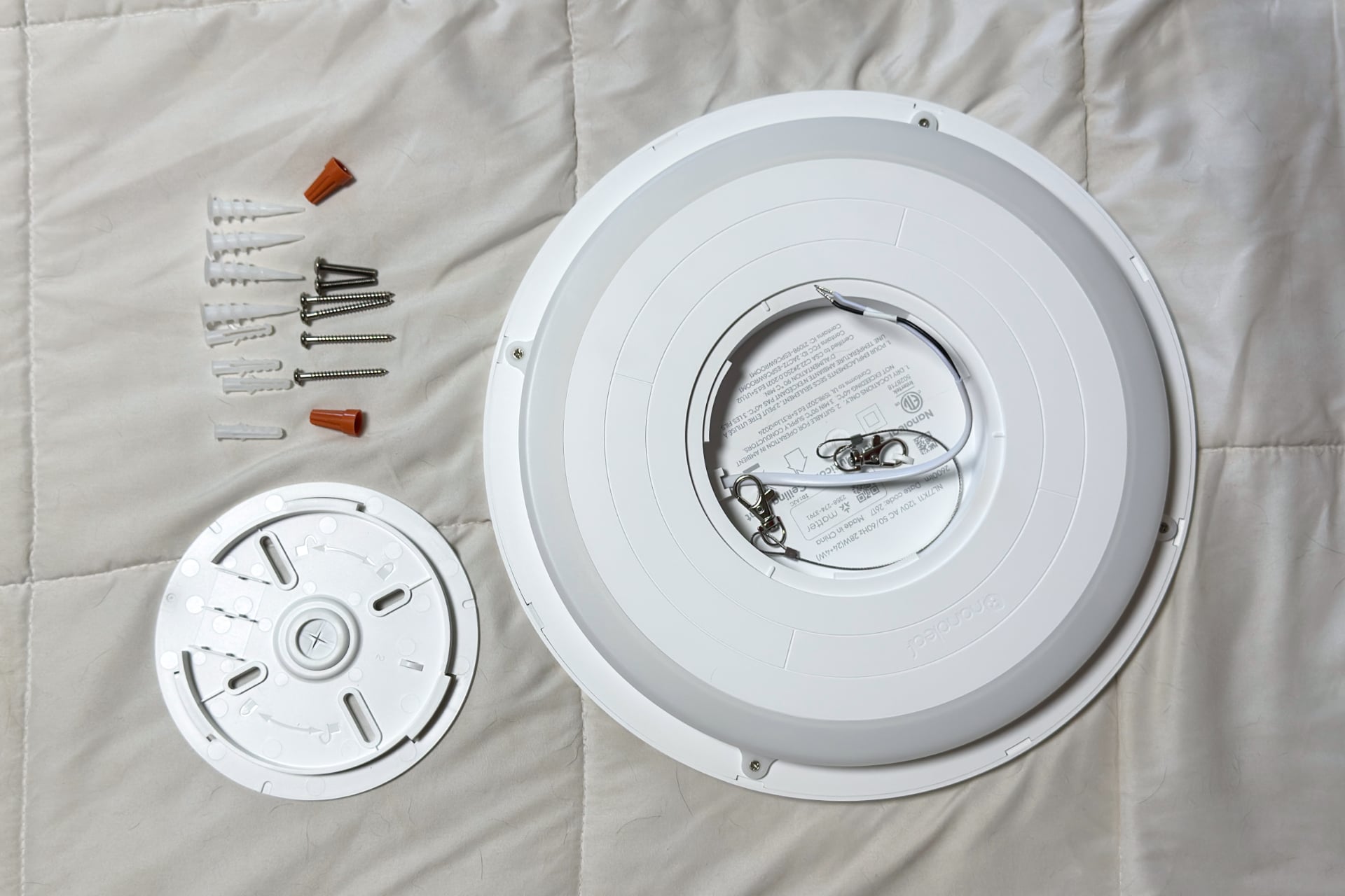 Nanoleaf Smart Multicolor Ceiling Light and its components laid out on a blanket.