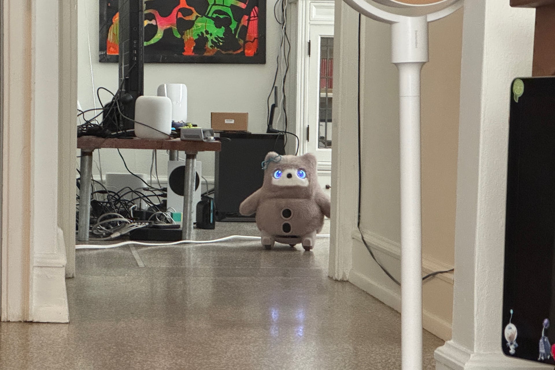 Switchbot Kata Friends pictured at a distance as it stands down a hallway, staring.