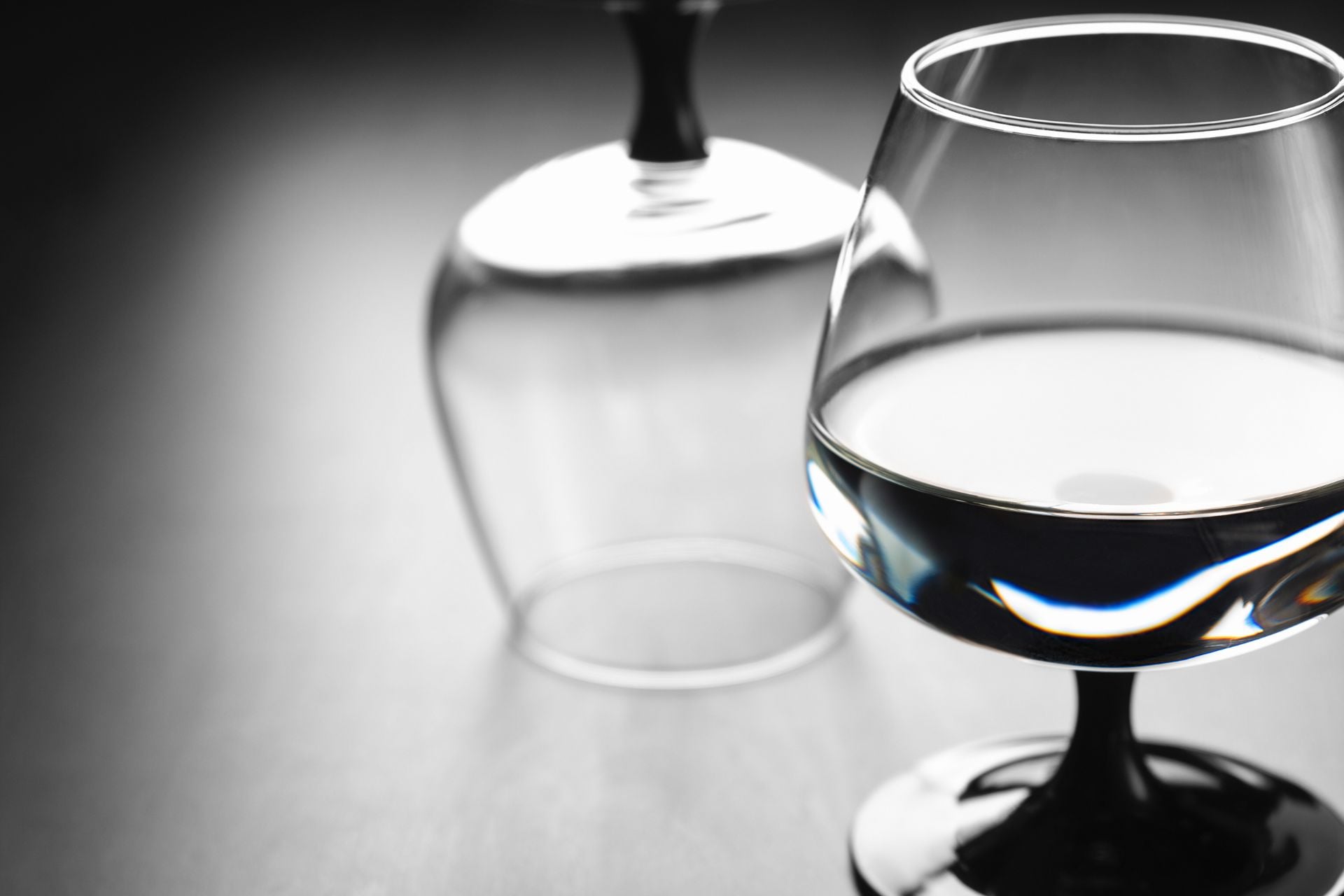 Two wine glasses, one filled with water.