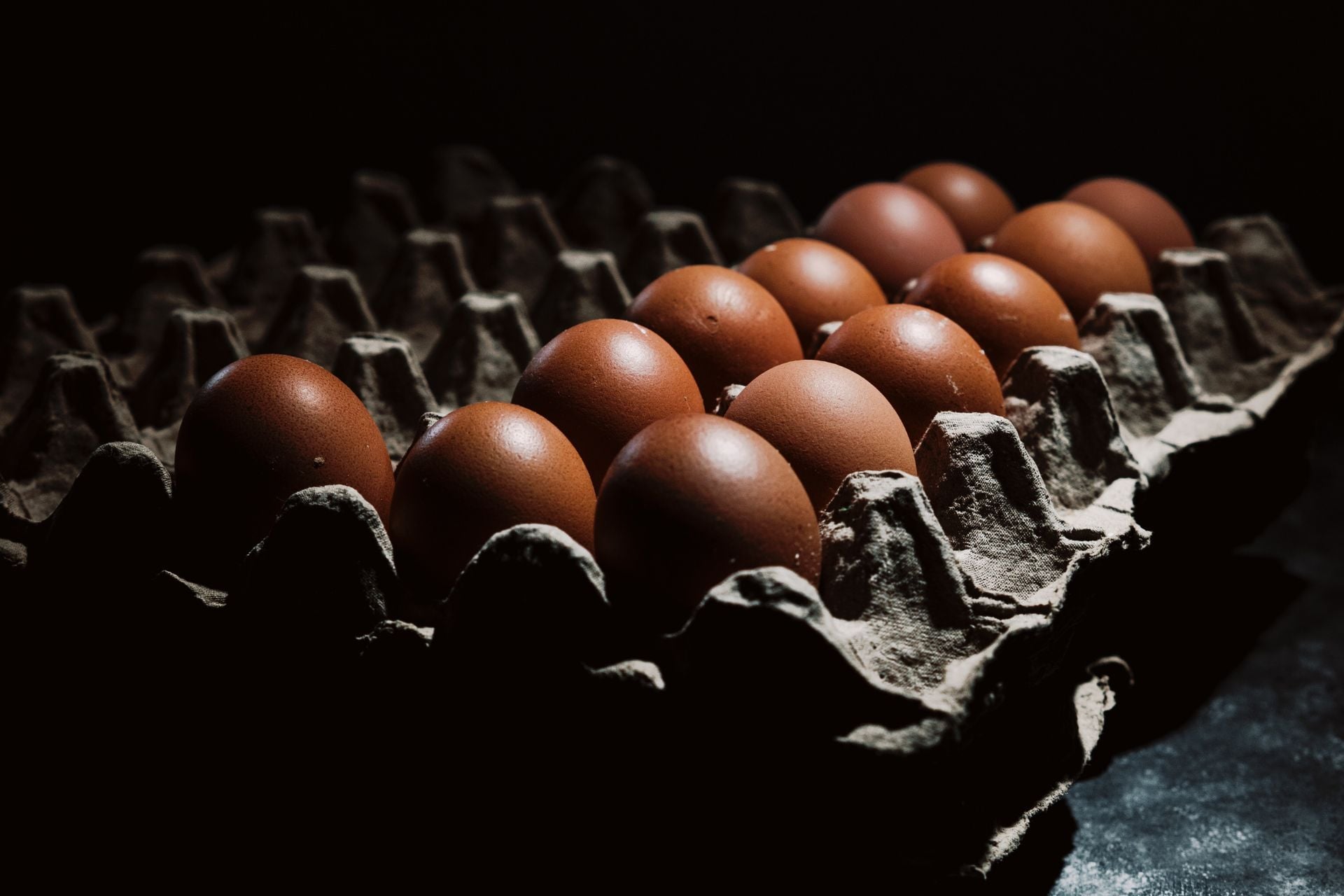 Eggs on a cardboard shelf.