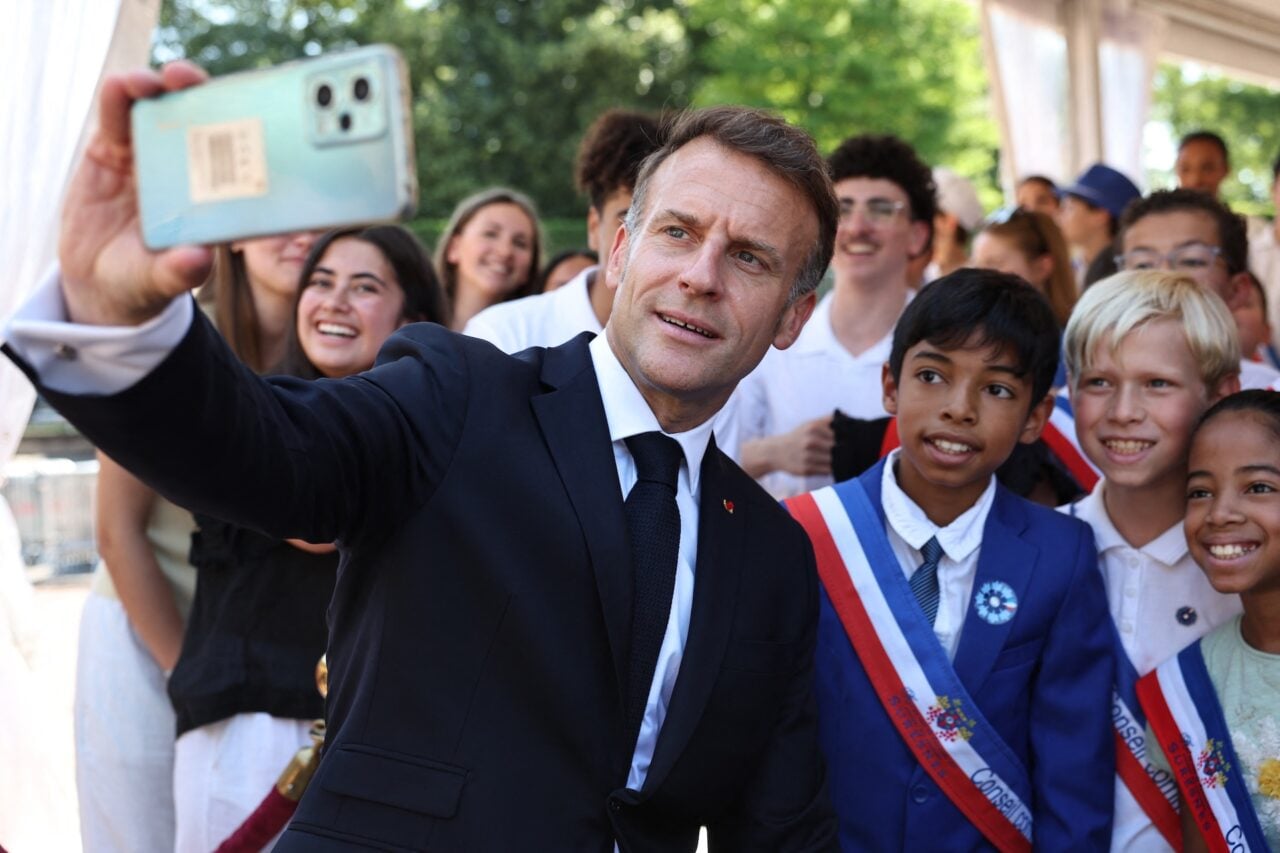 France's President Emmanuel Macron (L) poses for a selfie with guest children during the commemorative ceremony for the 86th anniversary of the Appeal of 18 June, at the Memorial du Mont-Valerien, in Suresnes, in the western suburbs of Paris, on June 18, 2026.