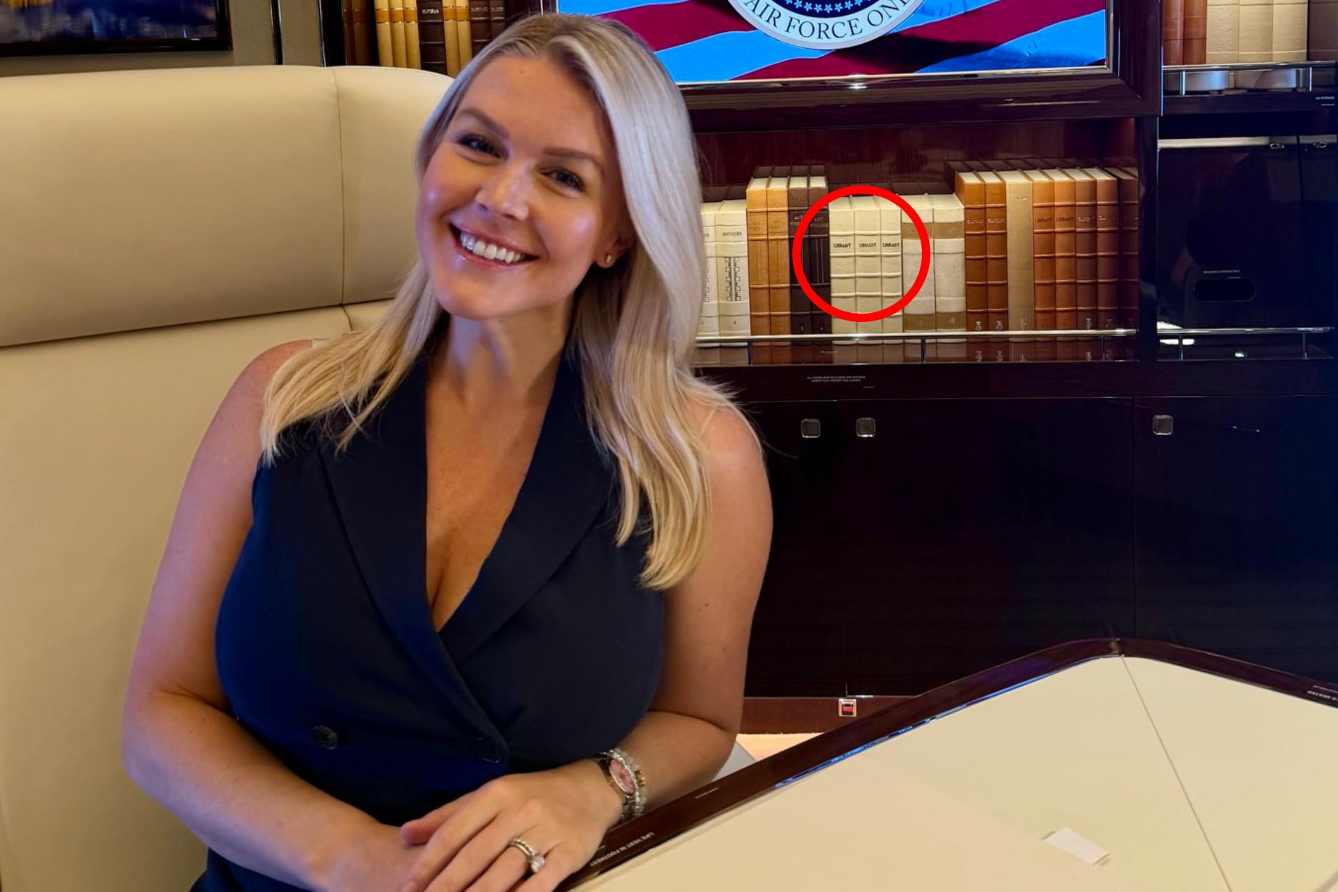 White House Press Secretary Karoline Leavitt in a photo posted to X on July 1, 2026, along with an annotation showing the books behind her. 