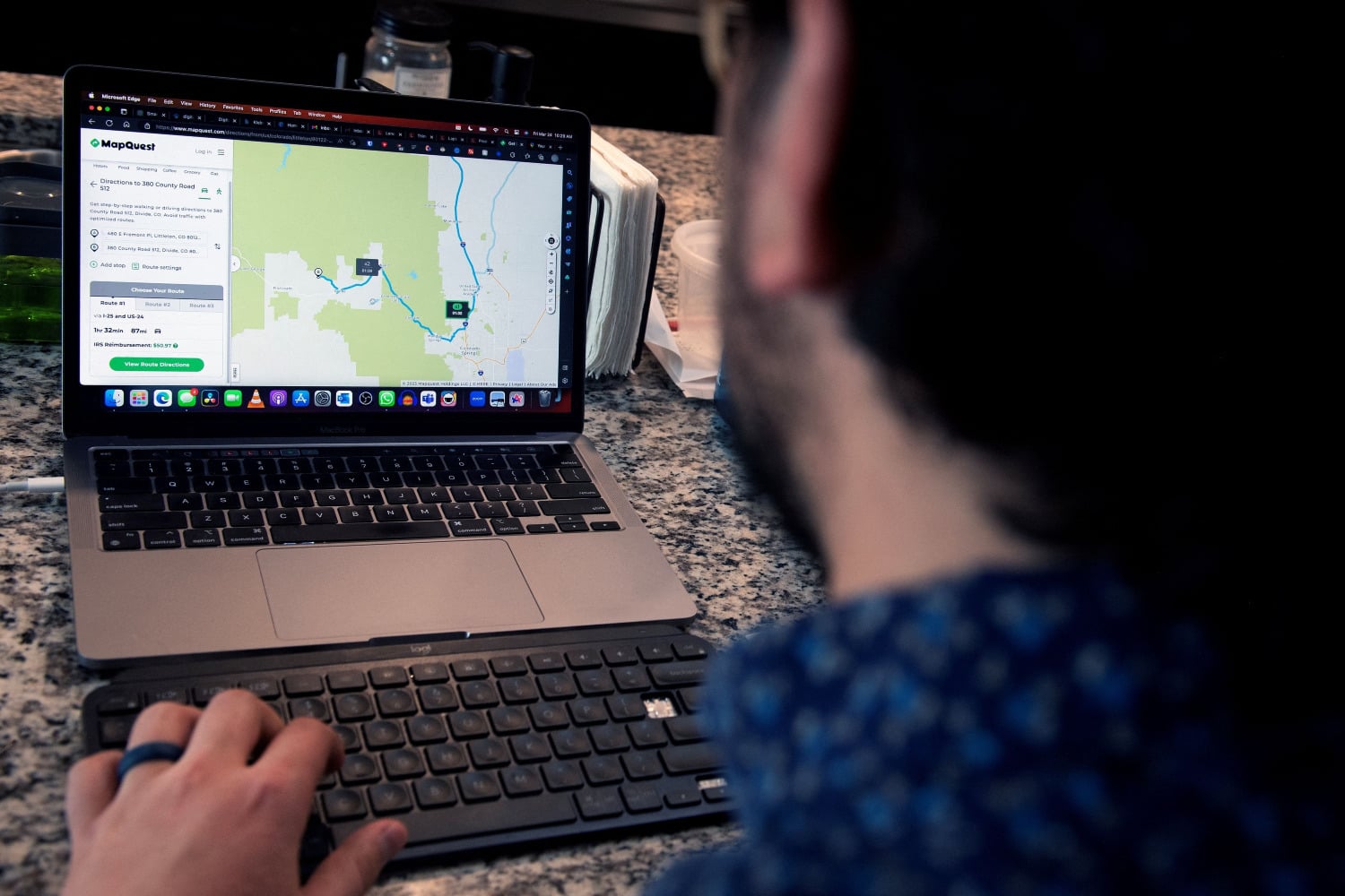 A person using a laptop with MapQuest displayed on it