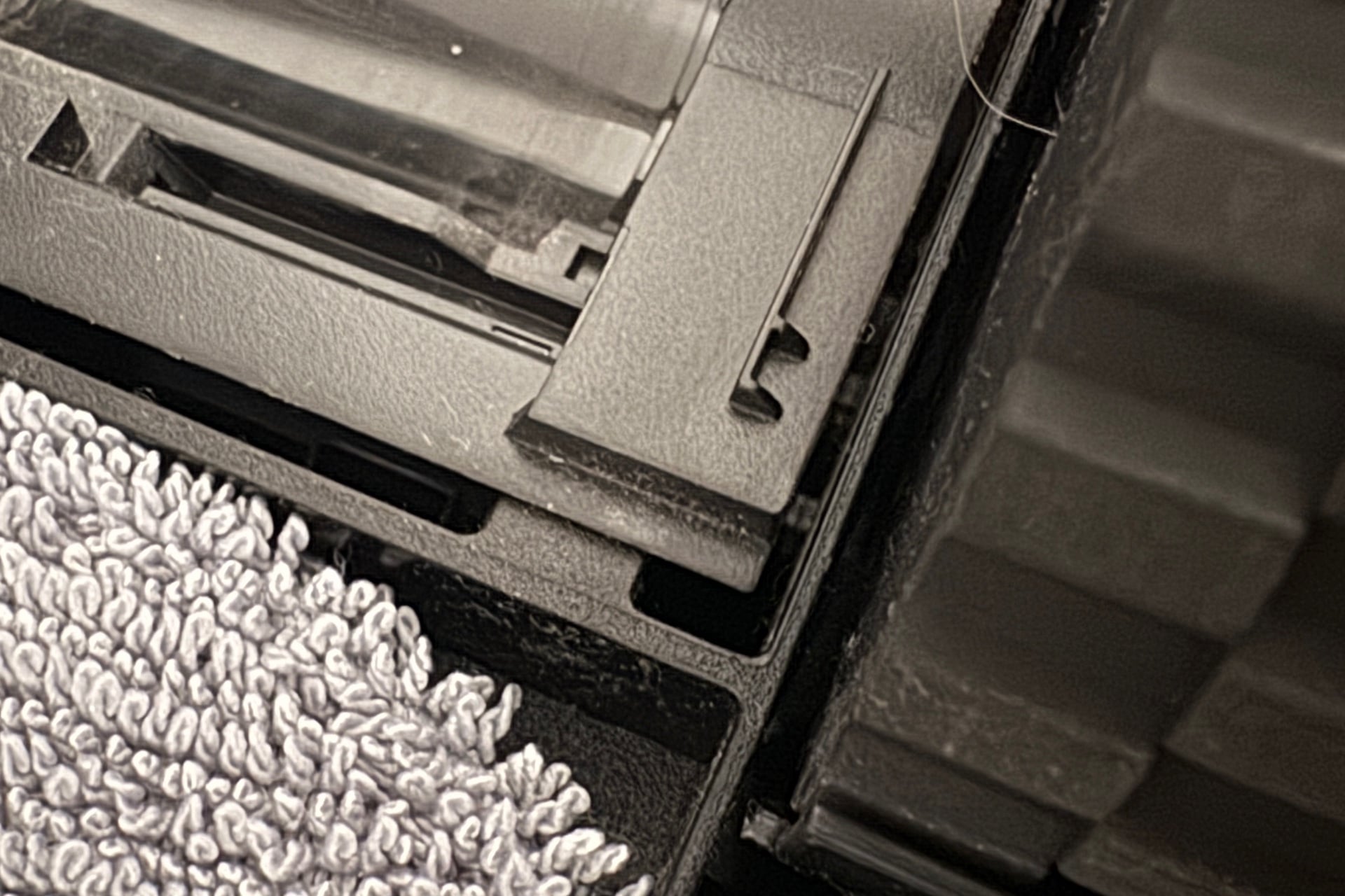Photo of the right side of the dust roller compartment, with the tab underneath instead of on top.