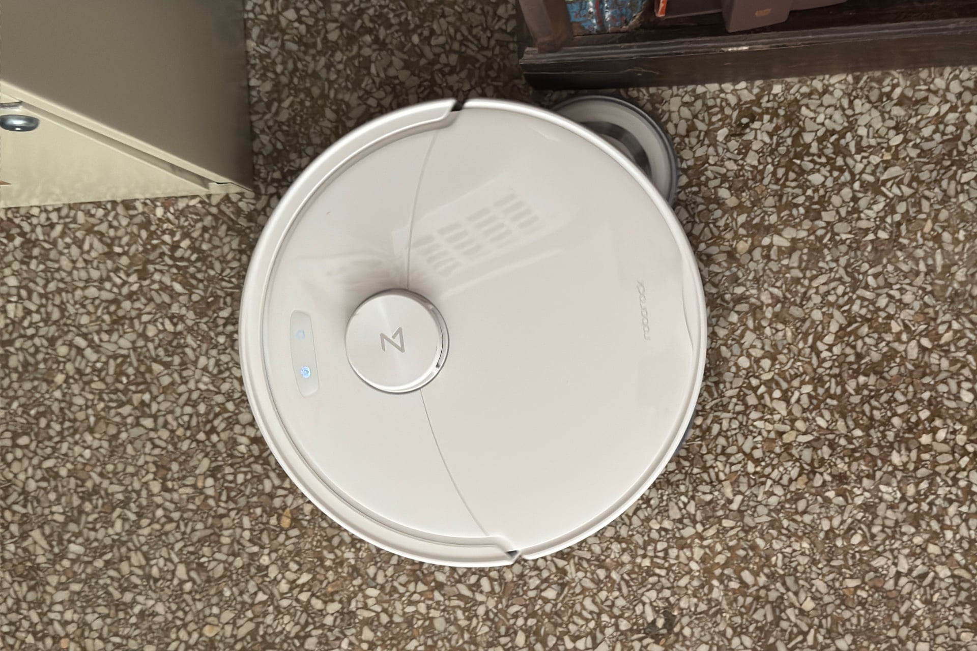 The Qrevo 2 Pro with its righthand mop pad extended up to the edge of a piece of furniture.