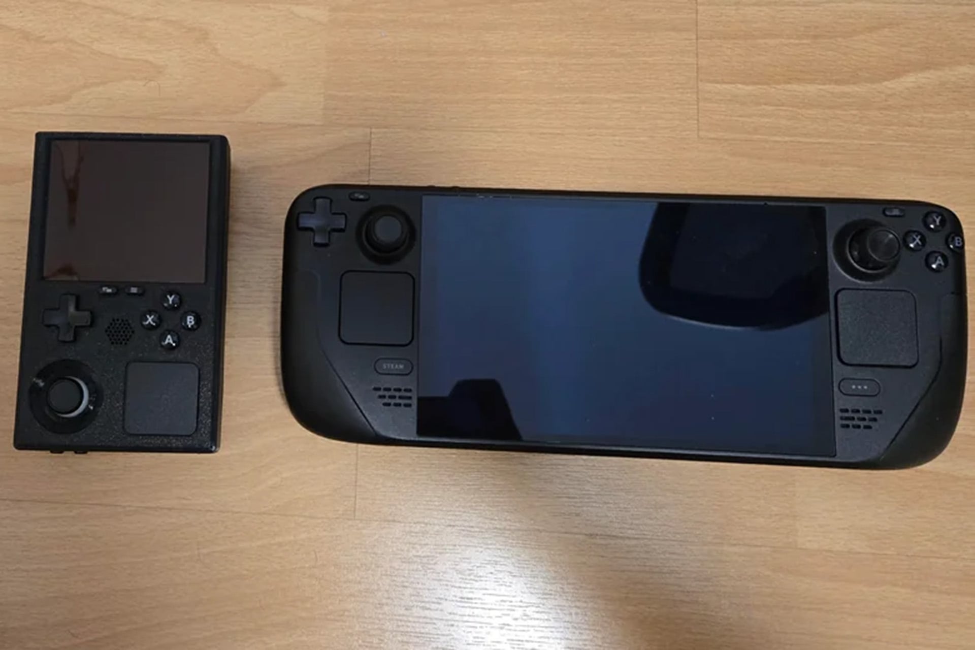 a modded 'Steamboy' handheld next to a SteamDeck on a table