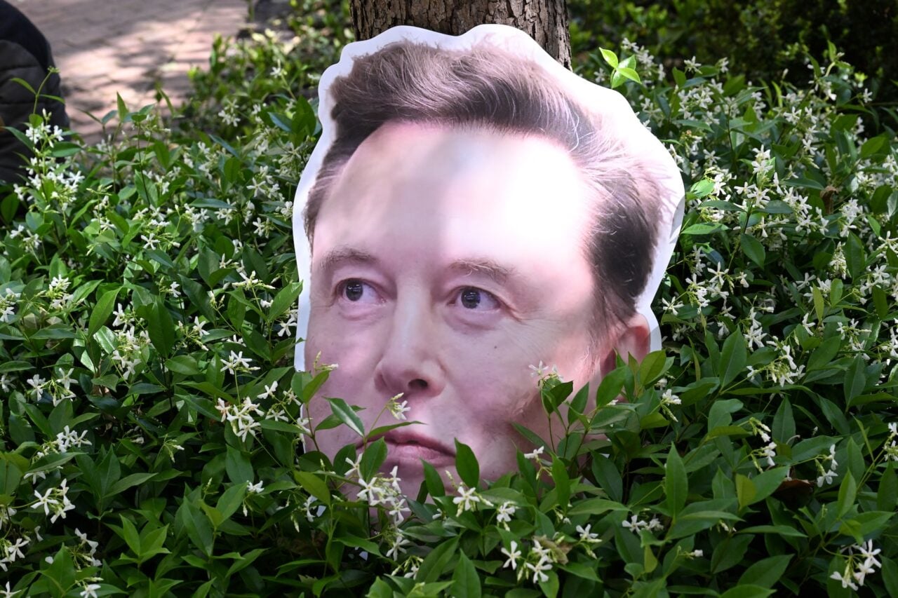 An Elon Musk sign sits in a bush the federal courthouse during proceedings in the trial over Elon Musk's lawsuit against OpenAI in Oakland, California, on April 30, 2026.