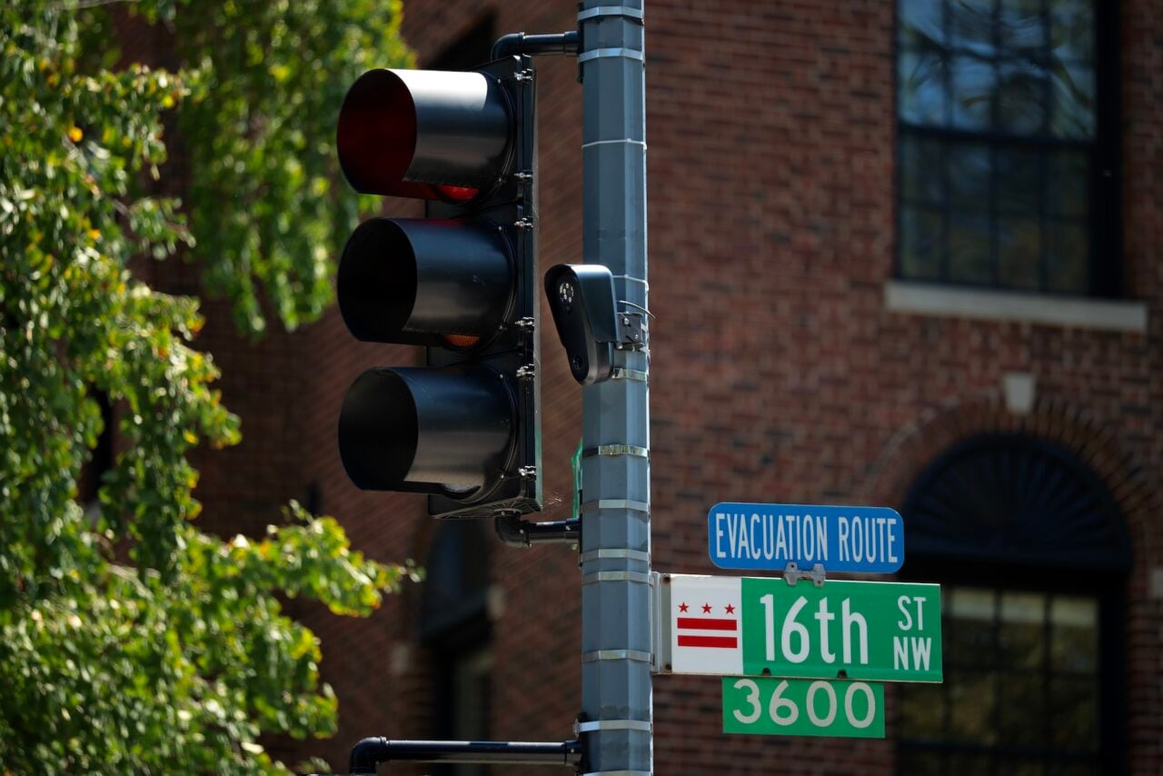 A Flock brand automatic license plate reader (ALPR) camera is attached to a traffic light pole along 16th Street Northwest on August 19, 2026 in Washington, DC.