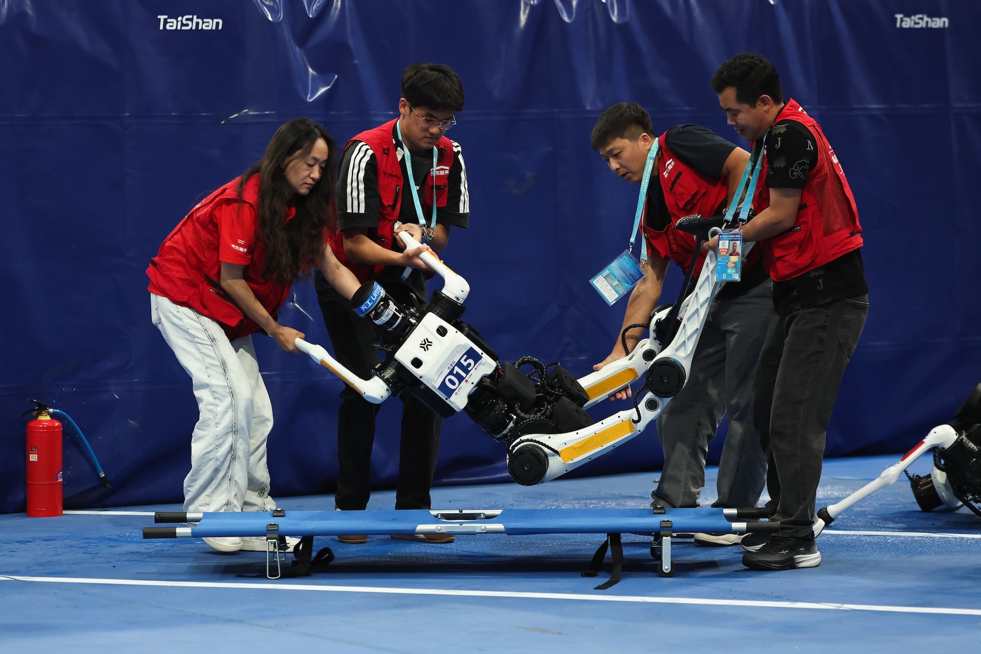 Maintenance team members use a stretcher to move a humanoid robot after it fell in a 100 meter race during the 2nd World Humanoid Robot Games at National Speed Skating Oval on August 25, 2026 in Beijing, China.