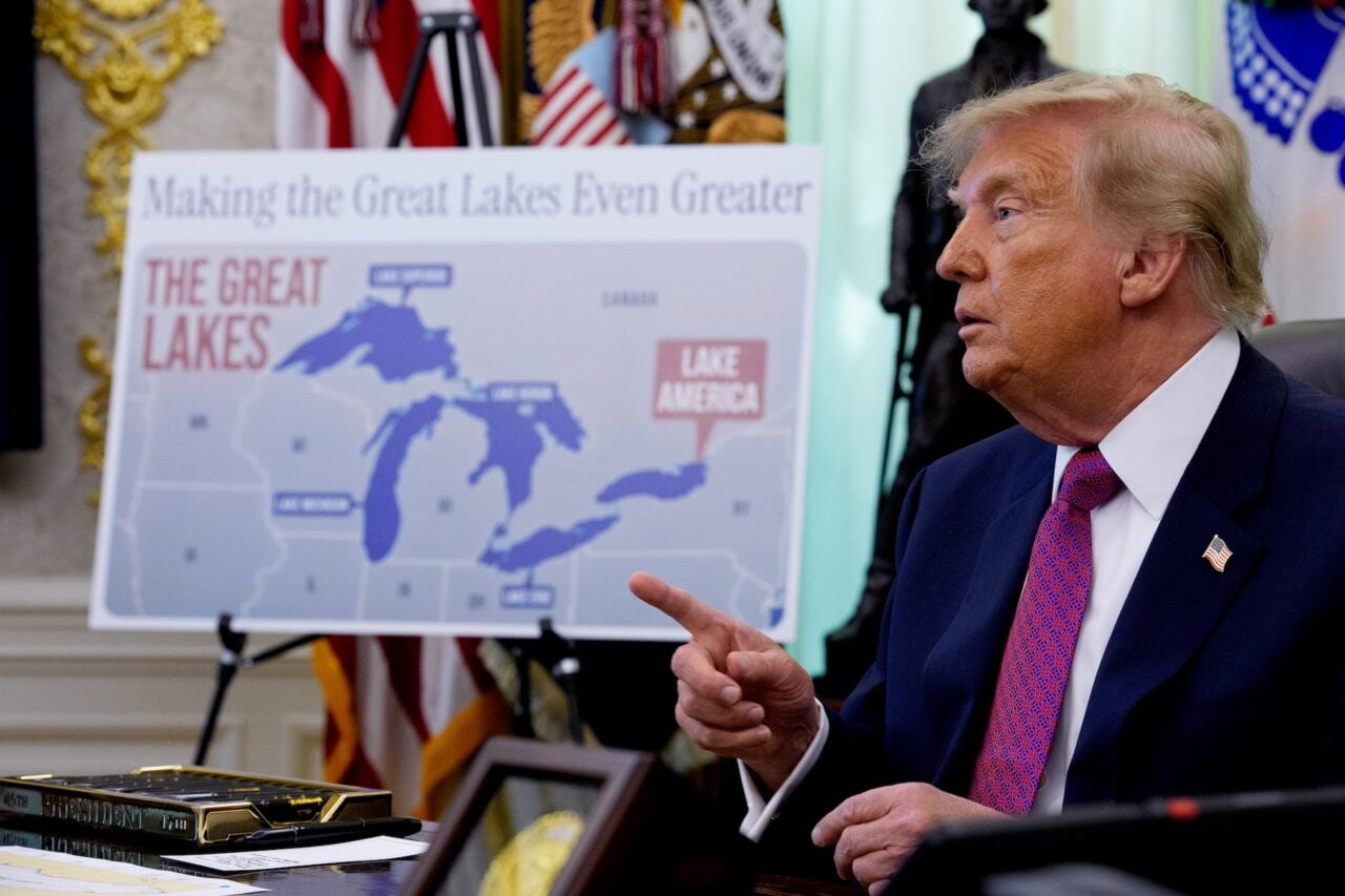 A map labeling Lake Ontario as "Lake America" is displayed as U.S. President Donald Trump takes a question from a reporter after signing an executive order during an event in the Oval Office of the White House on August 27, 2026 in Washington, DC.