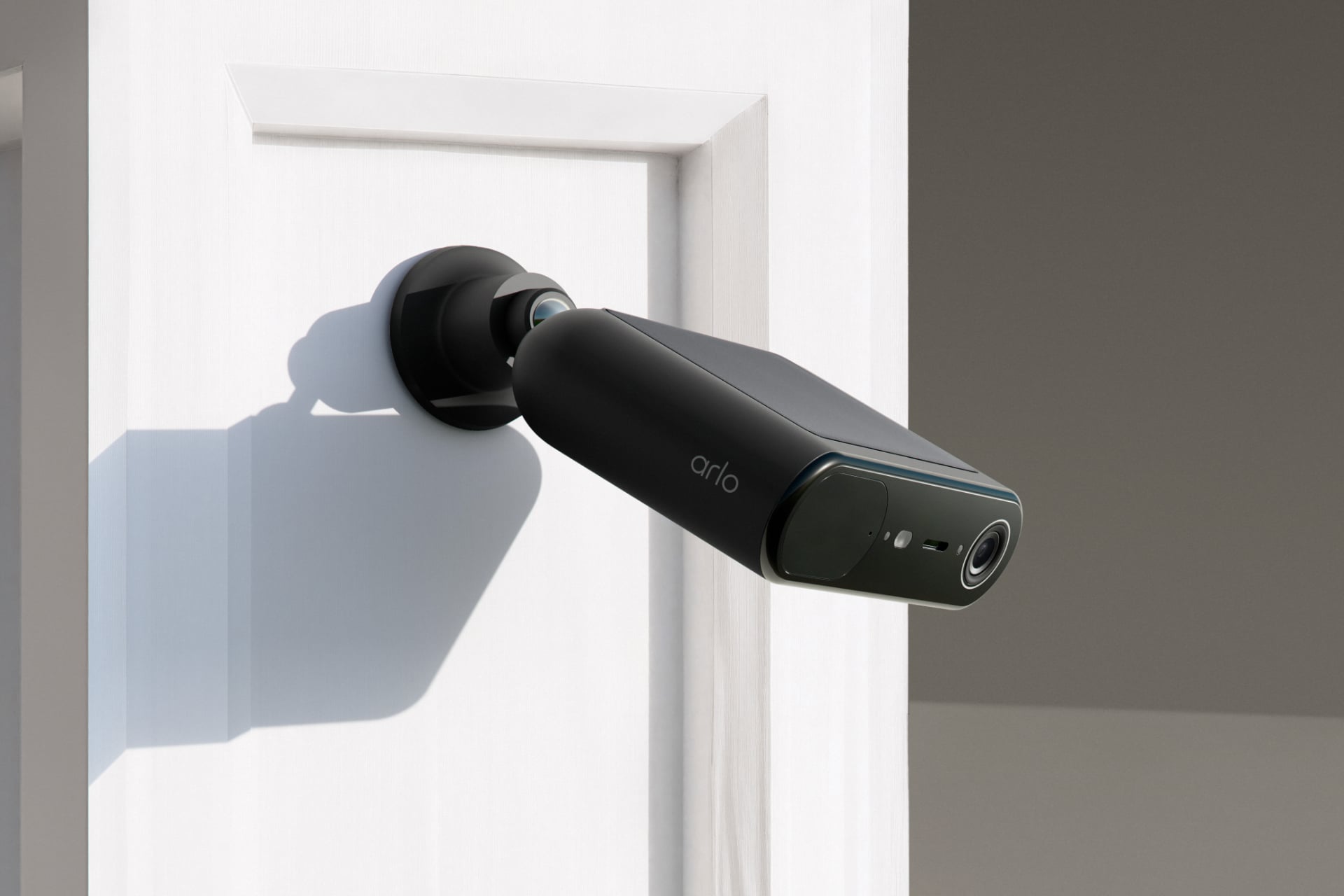 The Arlo Essential Solar camera in black, attached to a column.