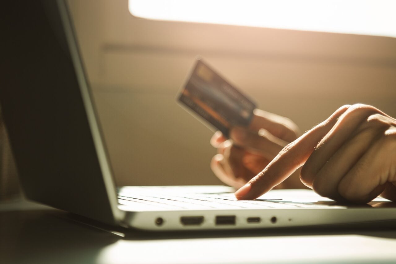 An image of someone with a credit card in front of a computer.
