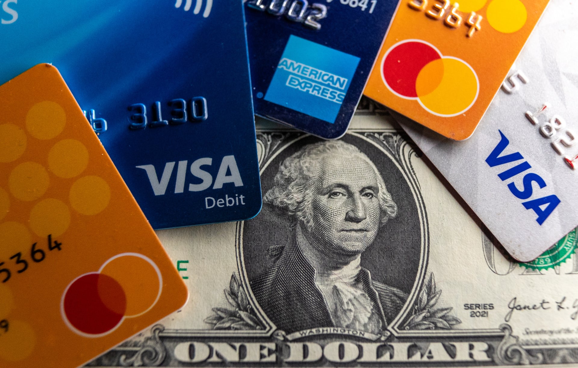 Several credit cards with the U.S. dollar in the background
