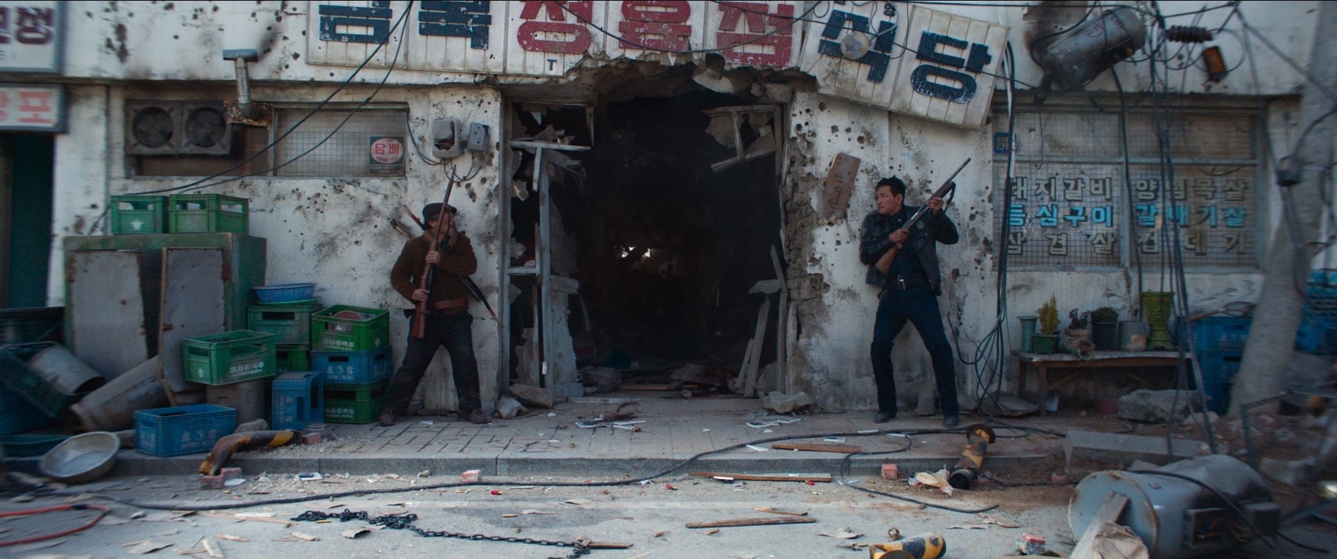 Hope still of an officer and a mercenary breaching a torn-down building.