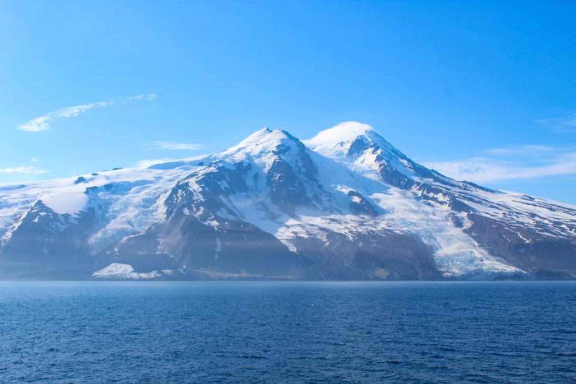 Triggered by a 6.5-magnitude earthquake, large quantities of volcanic and permafrost debris tumbled down at the Kjerulf Glacier, spreading the material across the surface and covering the ice right up to the coast on the left side of the image.