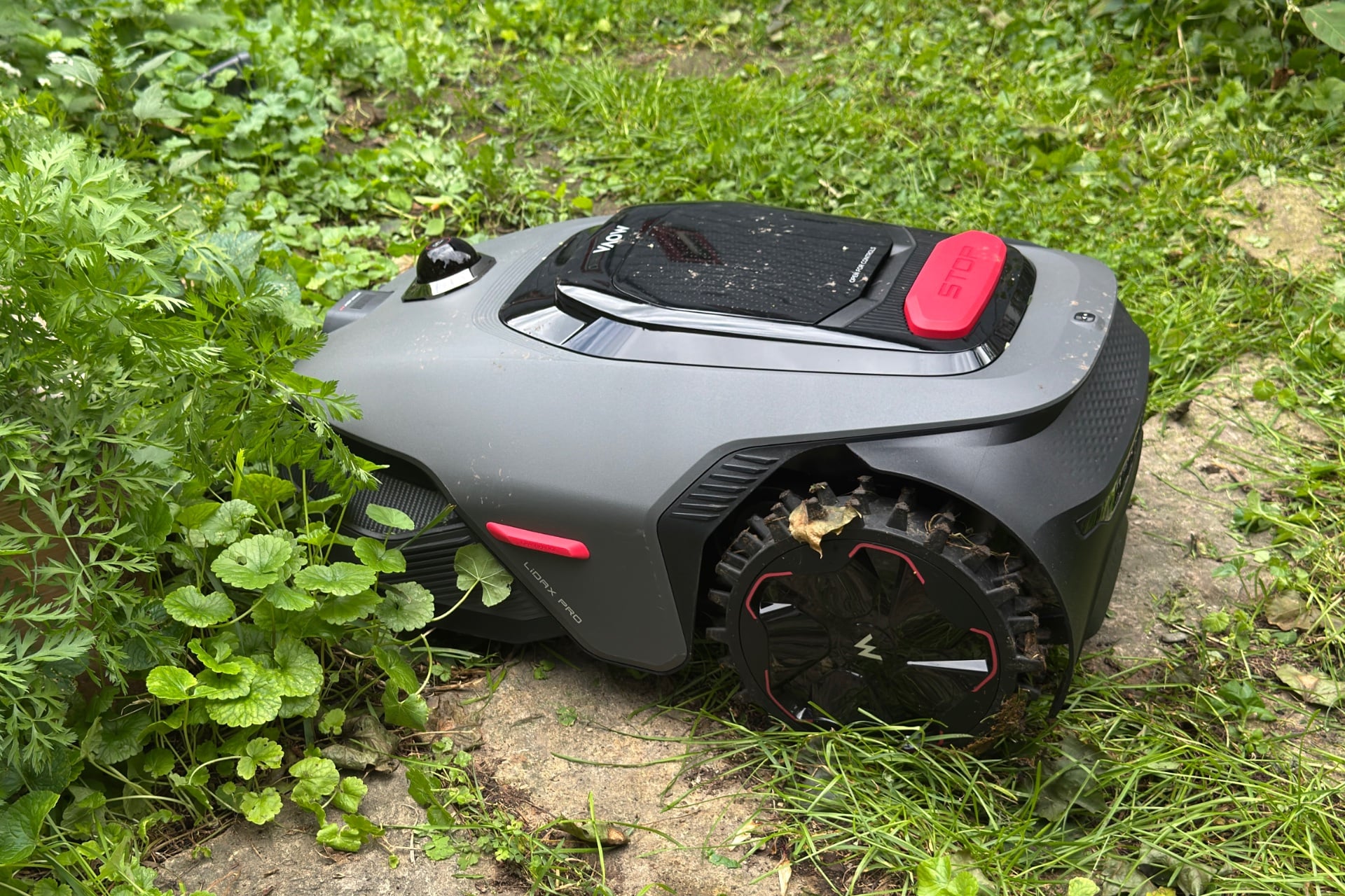 Mova Lidax Pro 800 pictured sitting in grass, with its left rear wheel stuck in pavers.