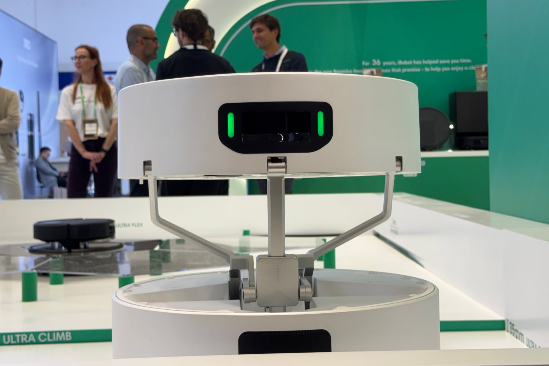 Roomba Duo's head unit from behind, as it's being raised up. Visible are the various arms and joints that support and help move it.