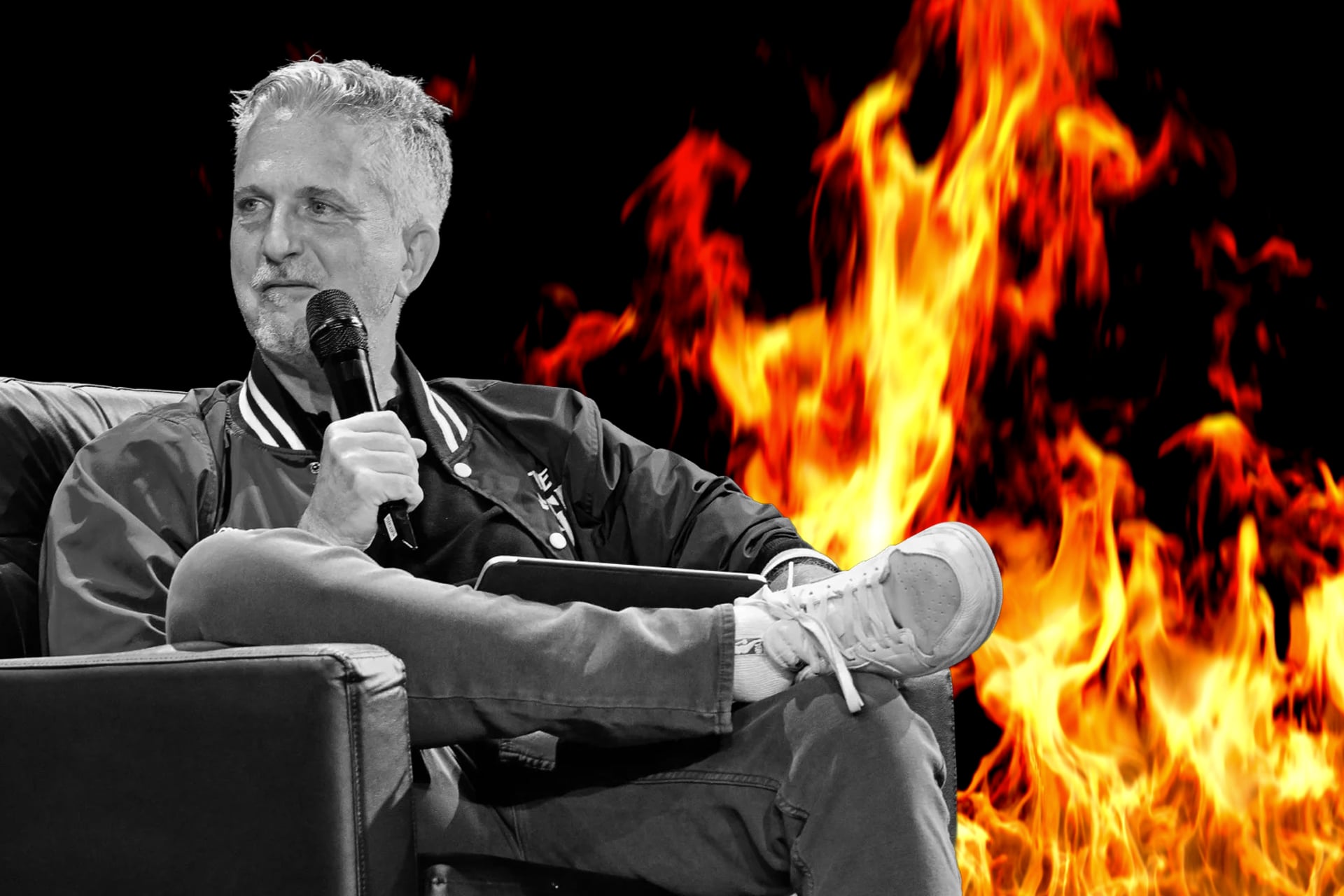 Bill Simmons sits in front of a wall of flames.
