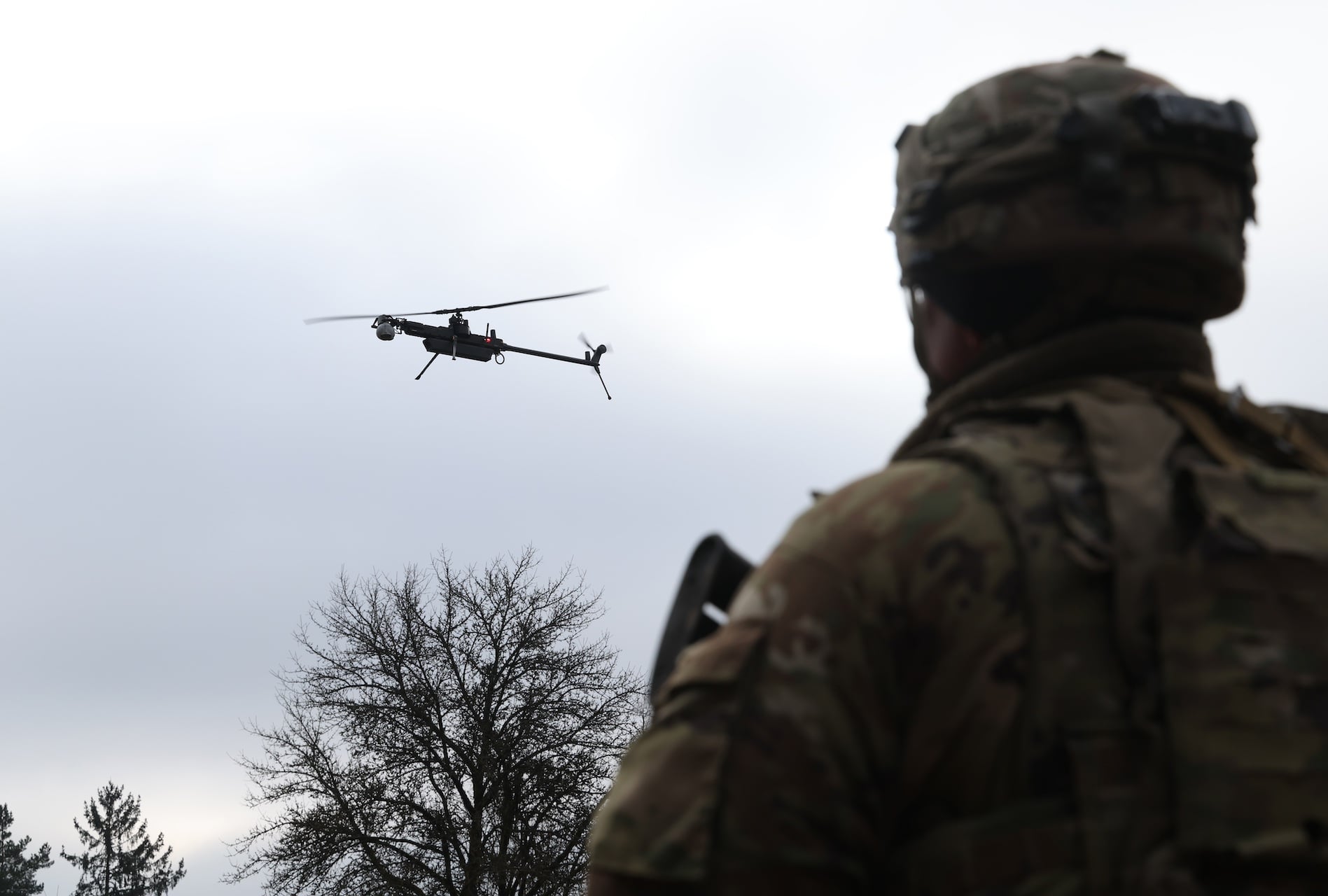 A U.S. Army soldier watches an Anduril Ghost-X helicopter surveillance drone land during a military exercise near Hohenfels, Germany in February 2025.