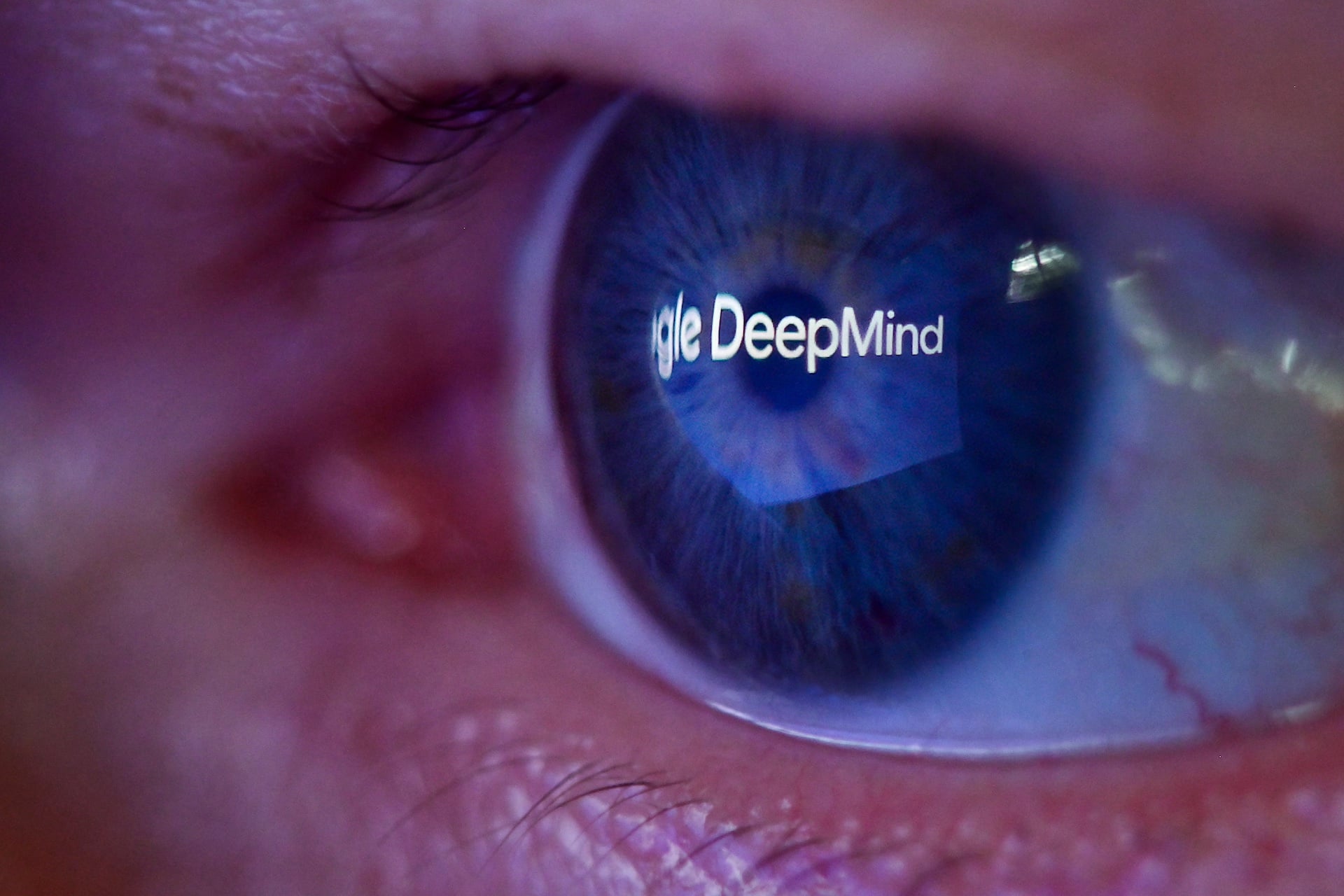 A photograph of a human eye reflecting the Google DeepMind logo.